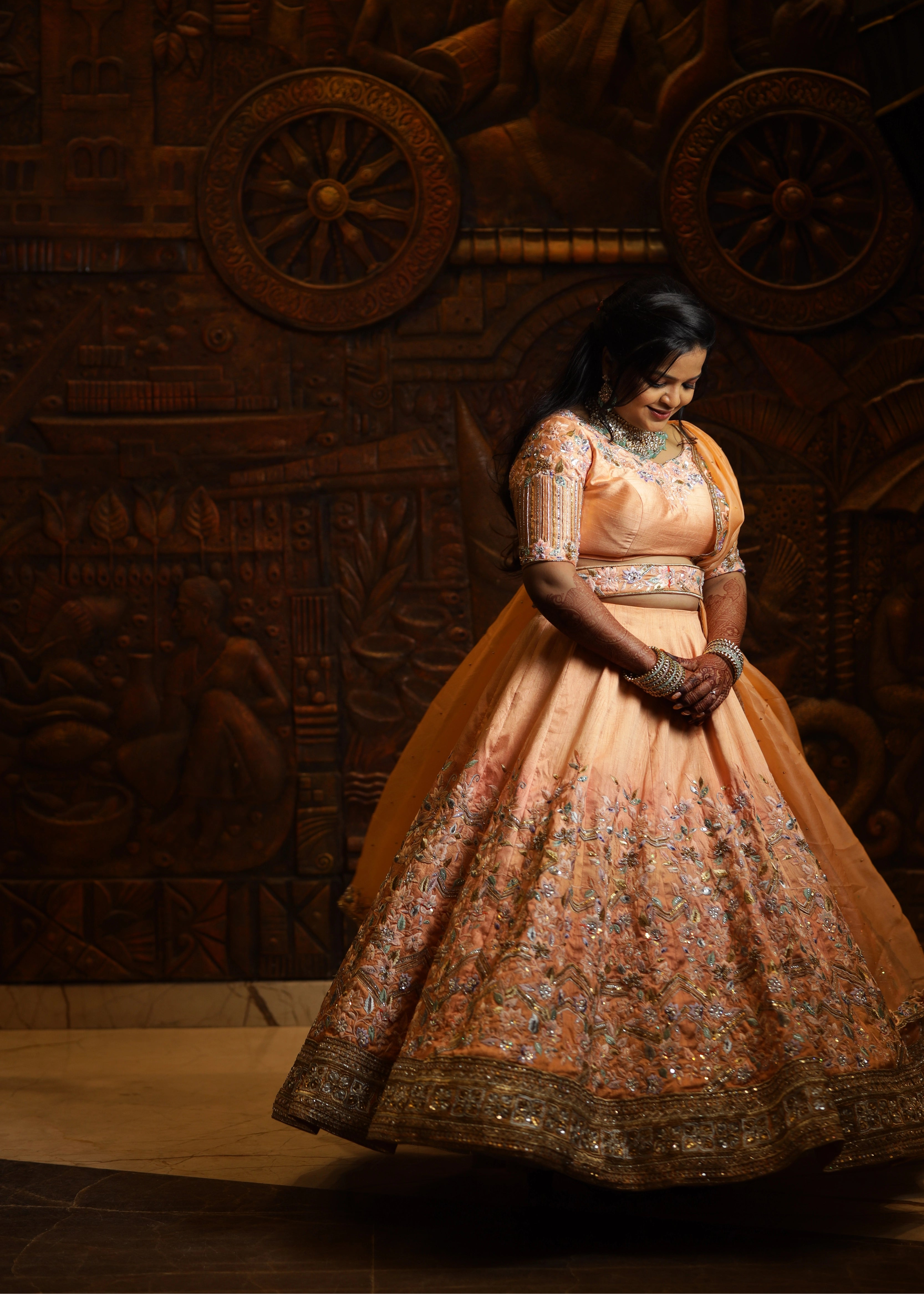 Bride from Singapore posing in a handcrafted peach lehenga designed by Archana Karthick