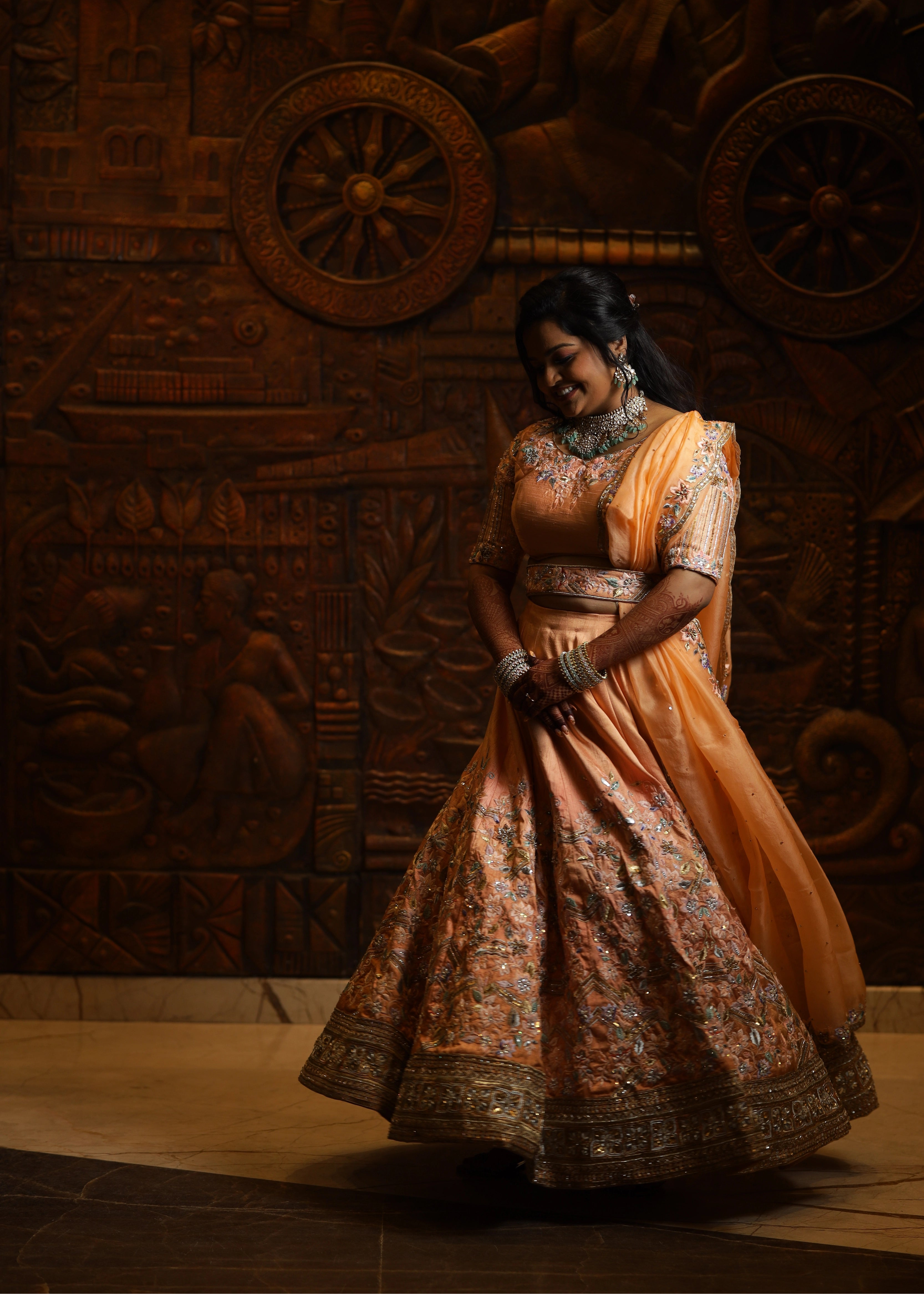 Bride from Singapore twirling in a handcrafted peach lehenga designed by Archana Karthick
