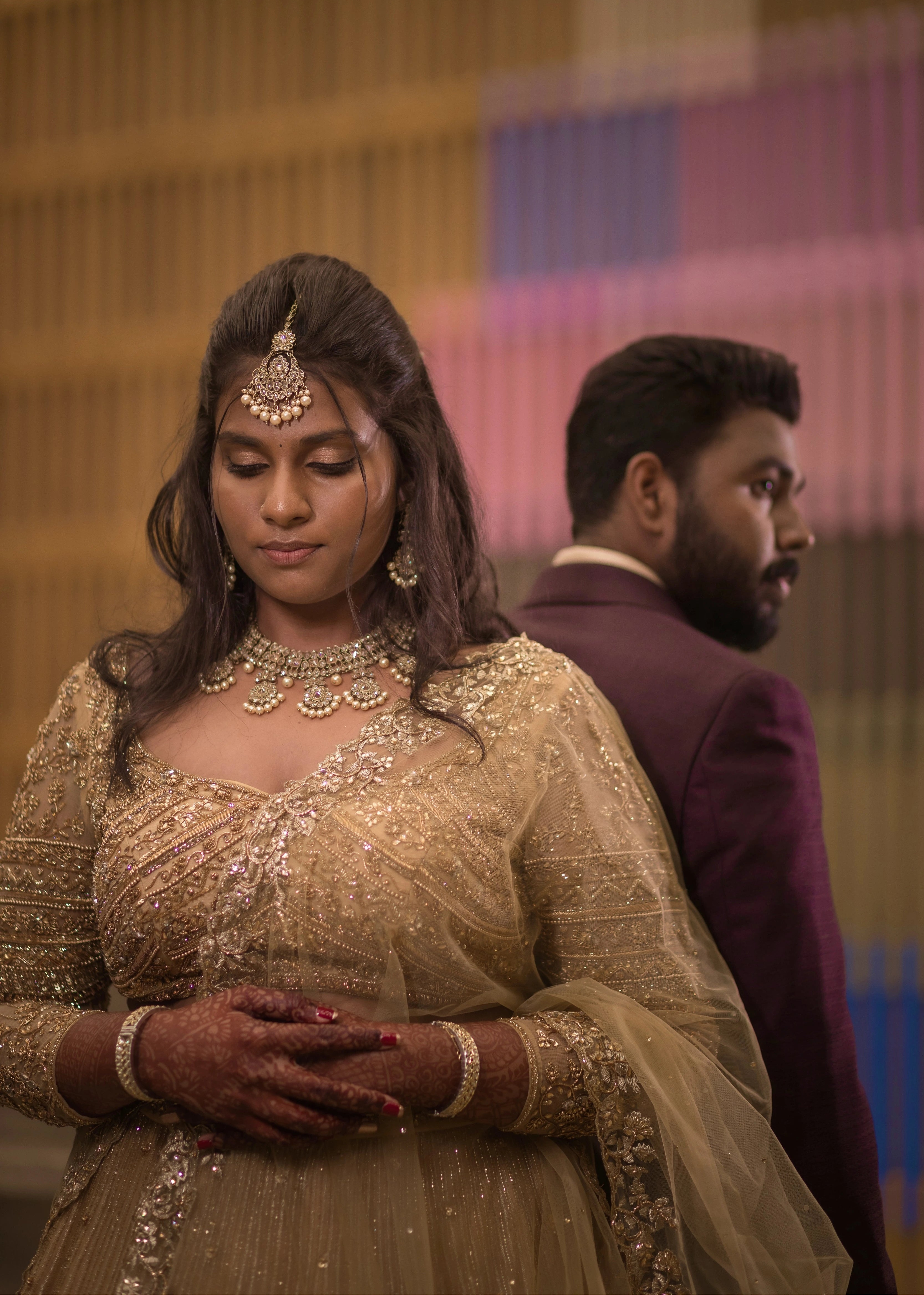 Bride from Singapore with groom in a gold lehenga in tulle designed by Archana Karthick handcrafted intricately with rhinestones, crystal beads, cutdanas and sequins.