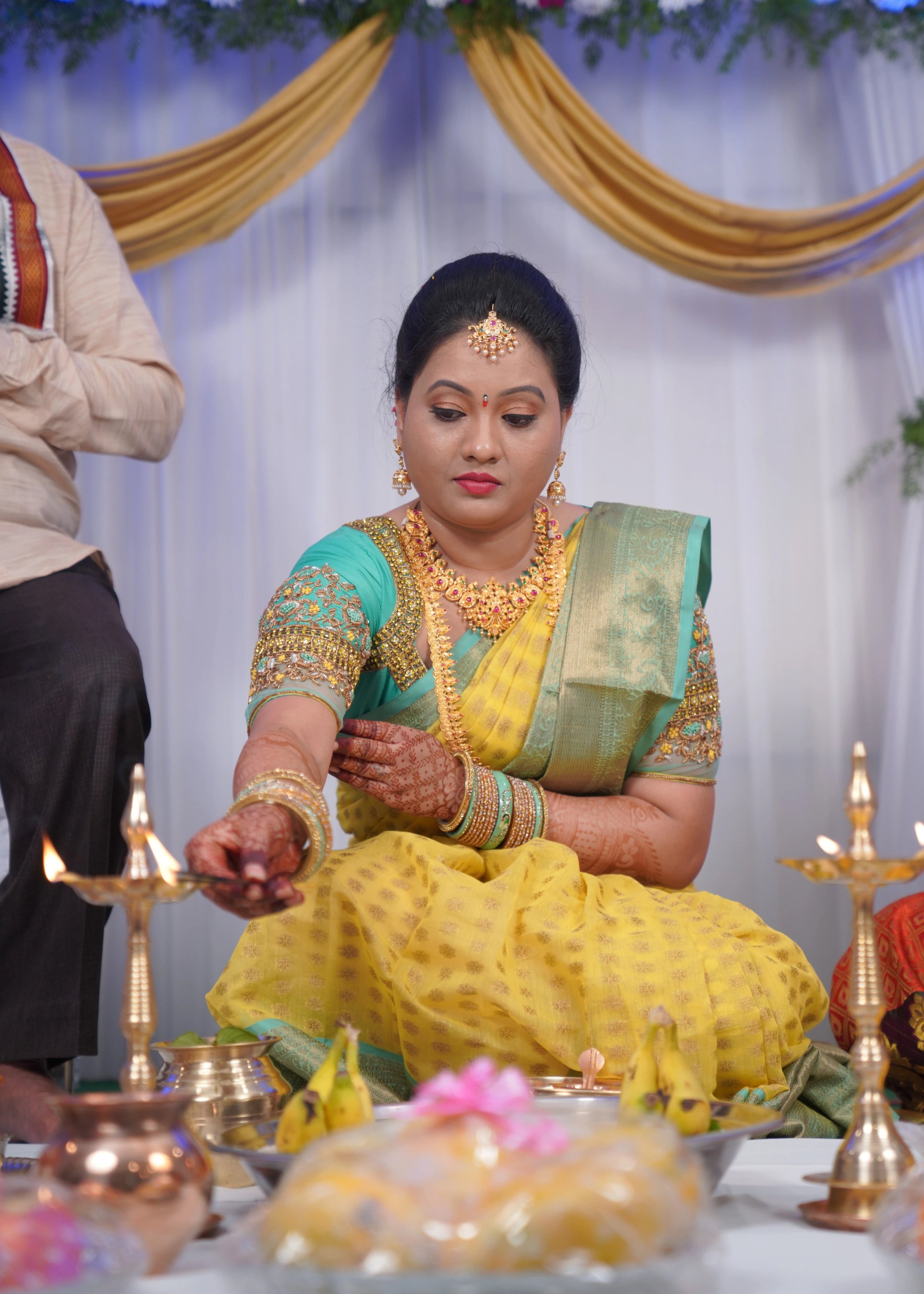 Bride from USA during rituals in an aquamarine blouse designed by Archana Karthick