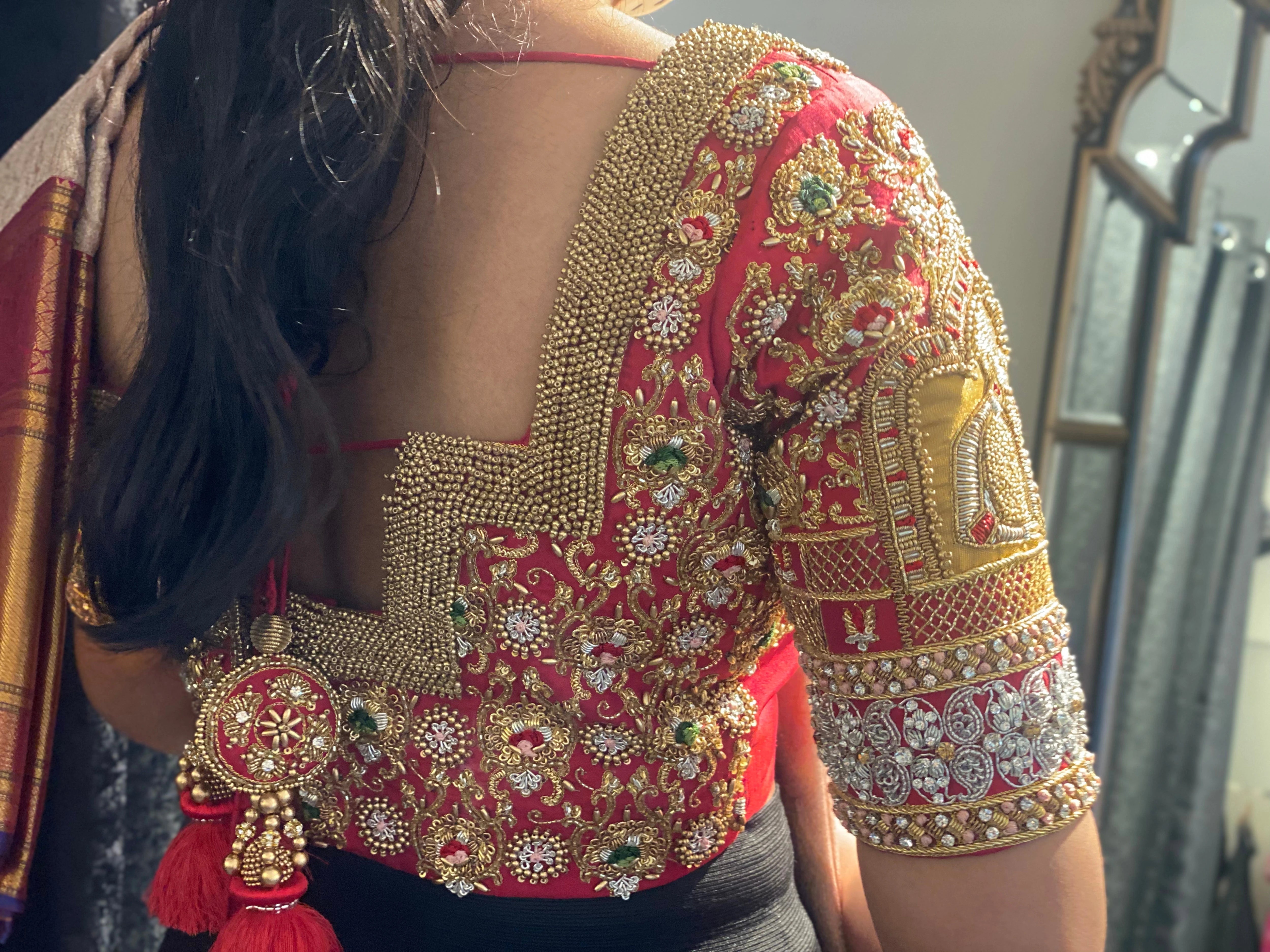 Bride in a red silk blouse during her fittings, handcrafted by team Archana Karthick.