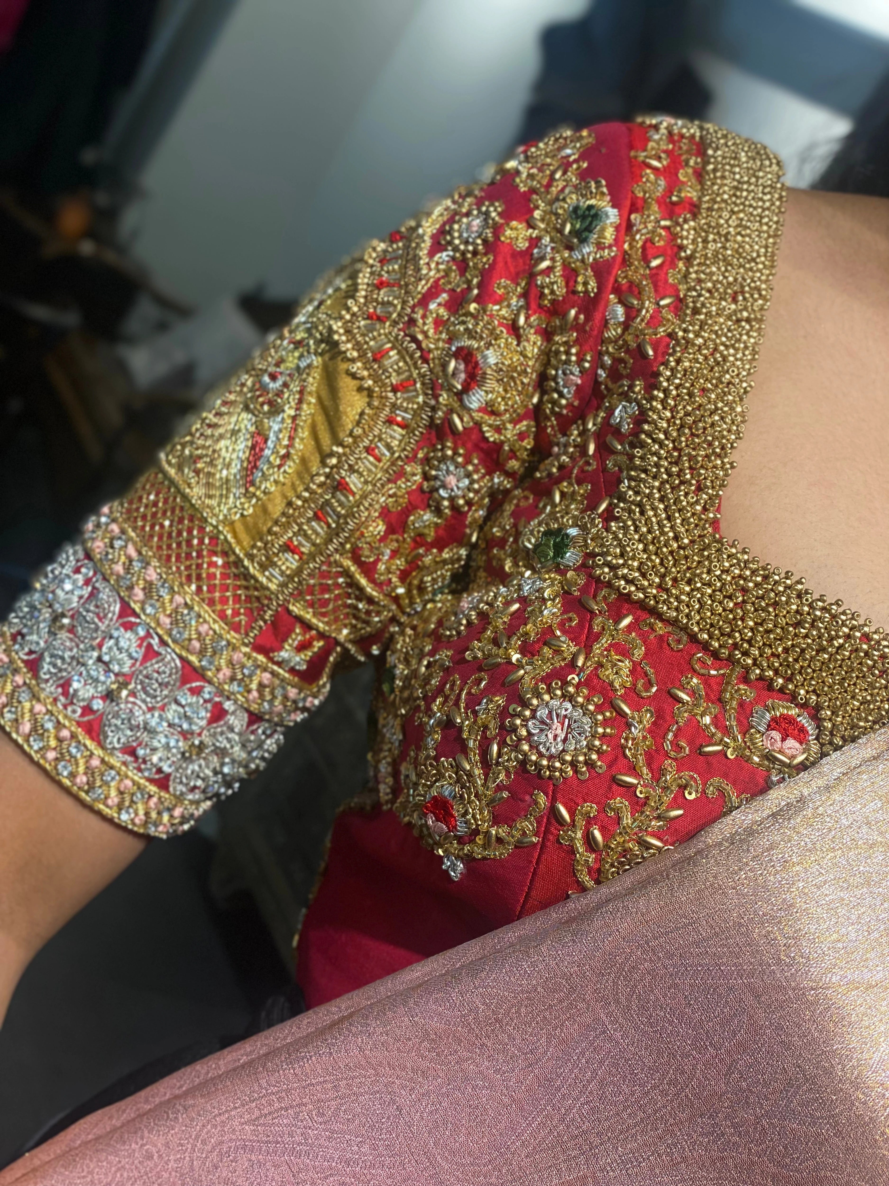 Bride in a red silk blouse during the fittings, handcrafted by team Archana Karthick.