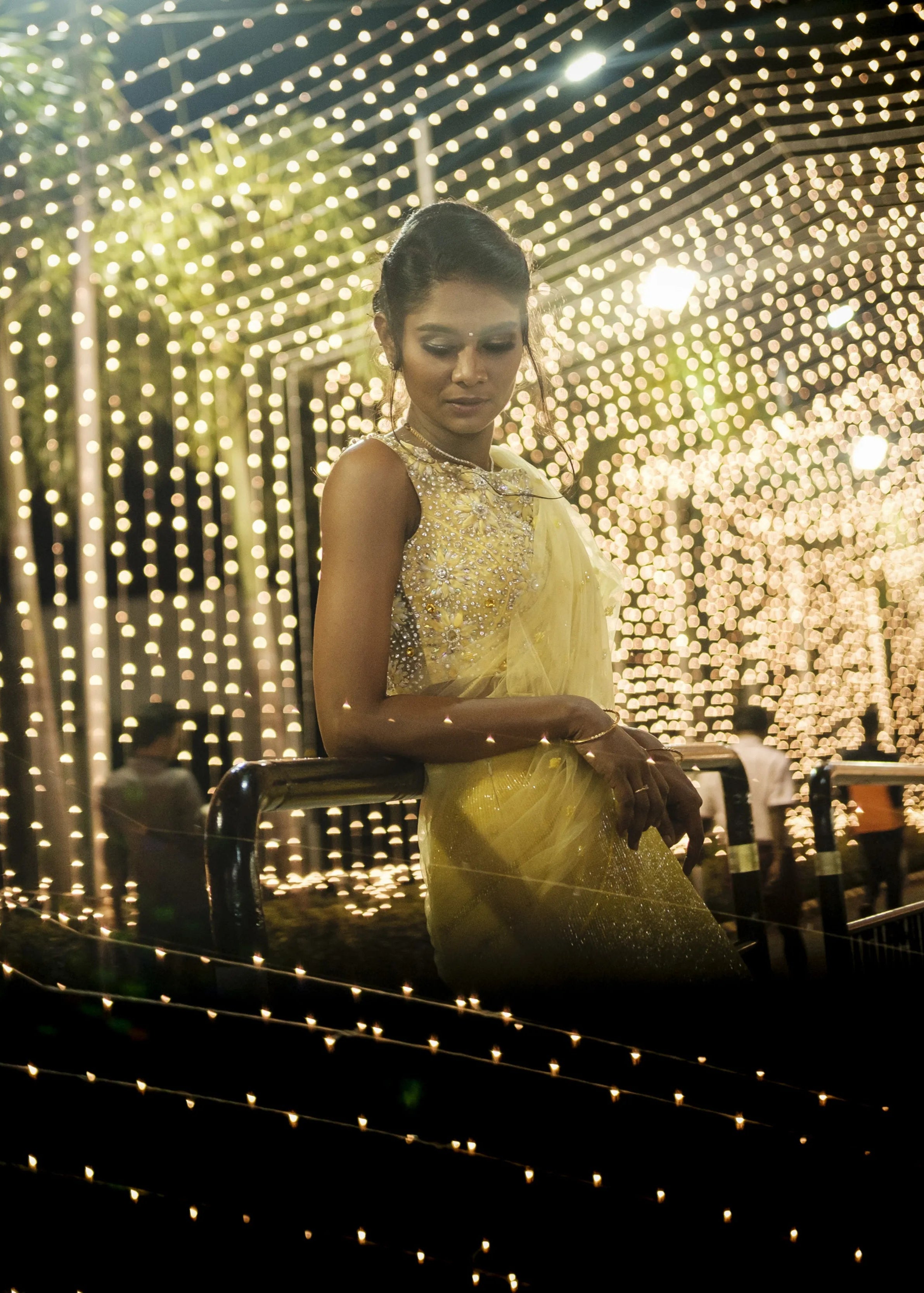 Bride posing for photoshoot in handcrafted yellow mermaid lehenga embellished with cut dana, pearls, rhinestones and handmade 3D flowers.