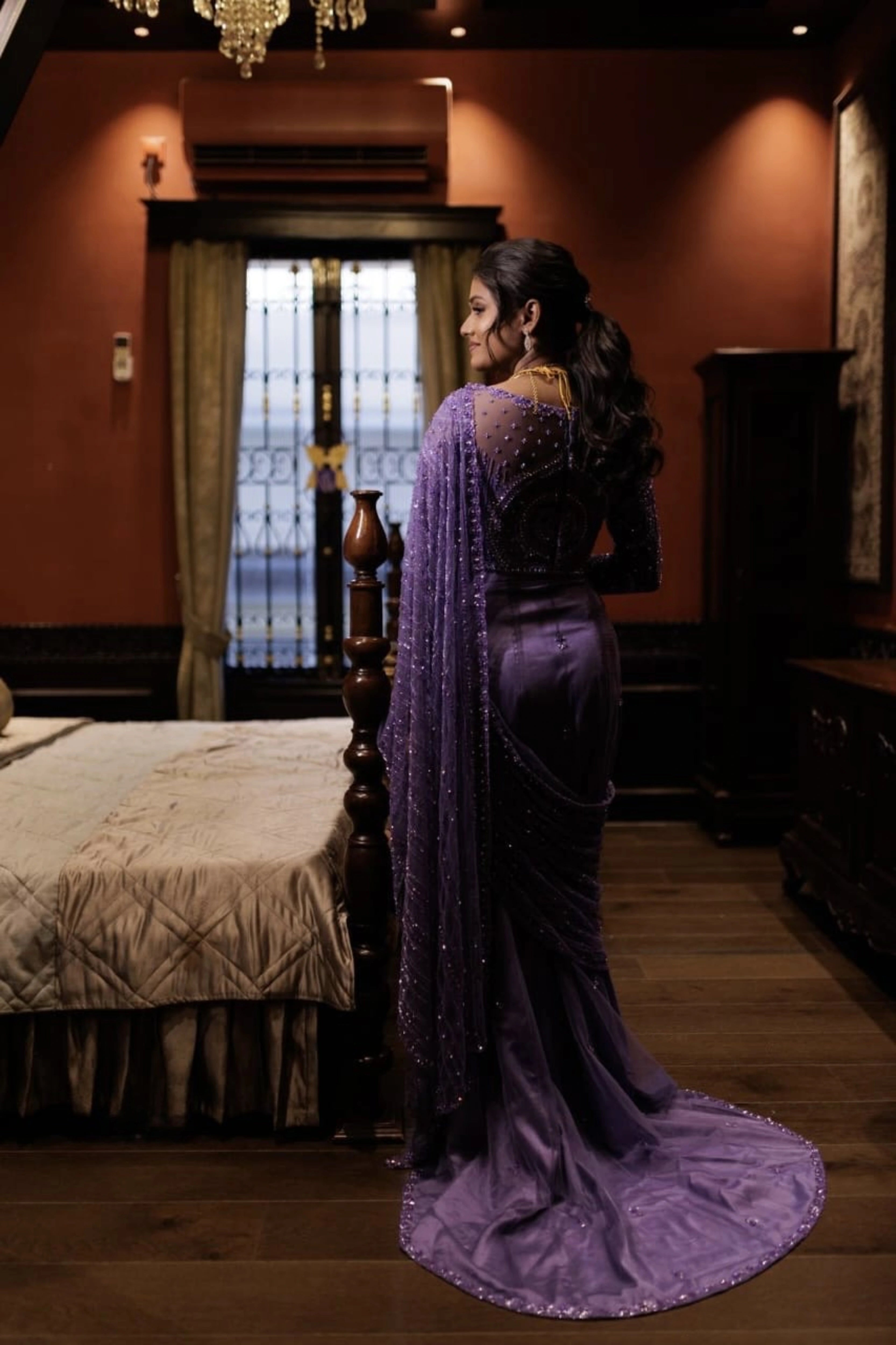 Bride Vishnu Karthika posing in a lavender tulle draped saree, handcrafted with rhinestones, zardozi, sequins, crystals, cutdana and resham by team Archana Karthick.