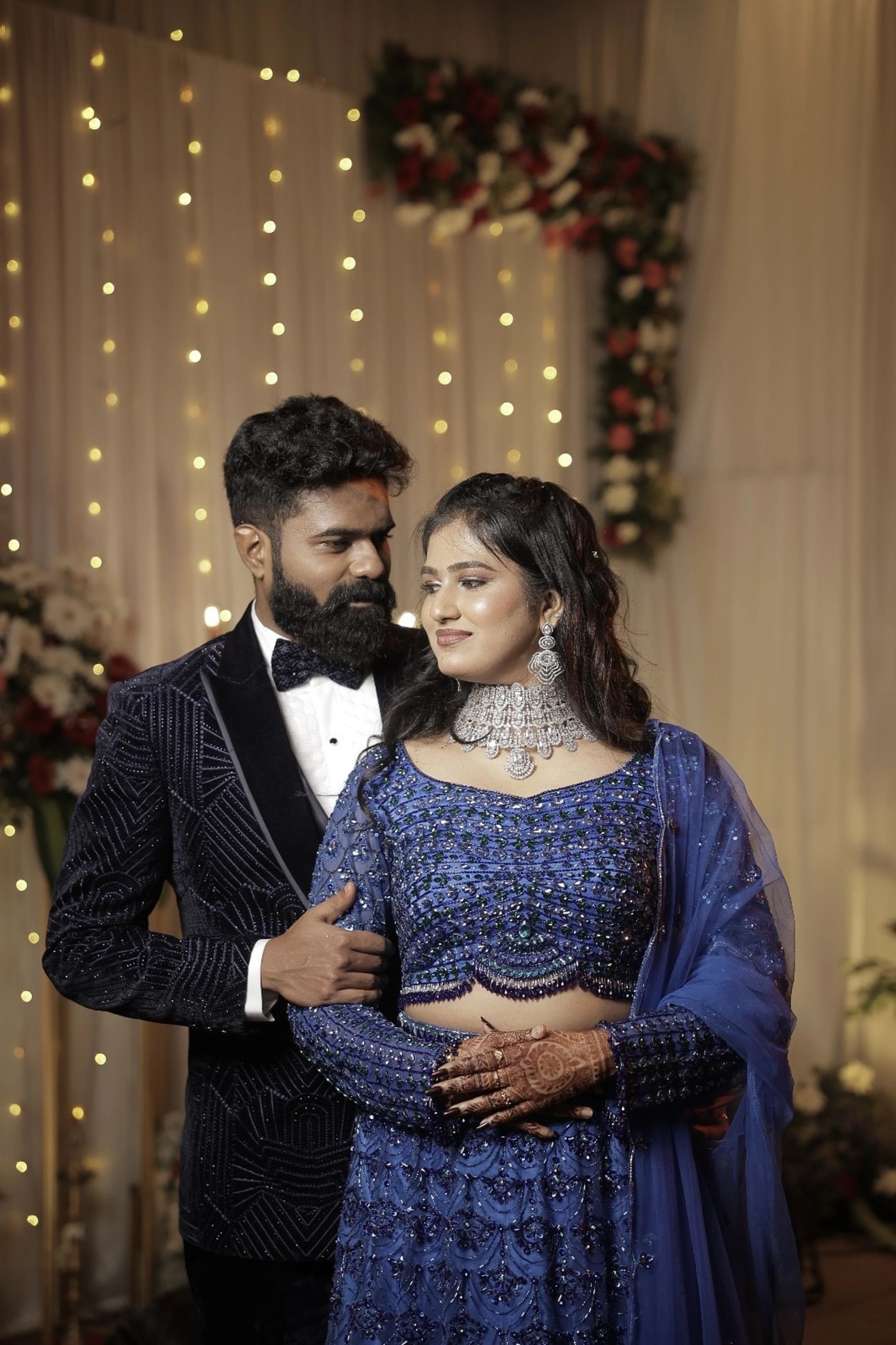 Bride Monishka posing in a peacock themed blue ombre tulle lehenga, handcrafted with sequins, cutdana, rhinestones and feathers by team Archana Karthick.