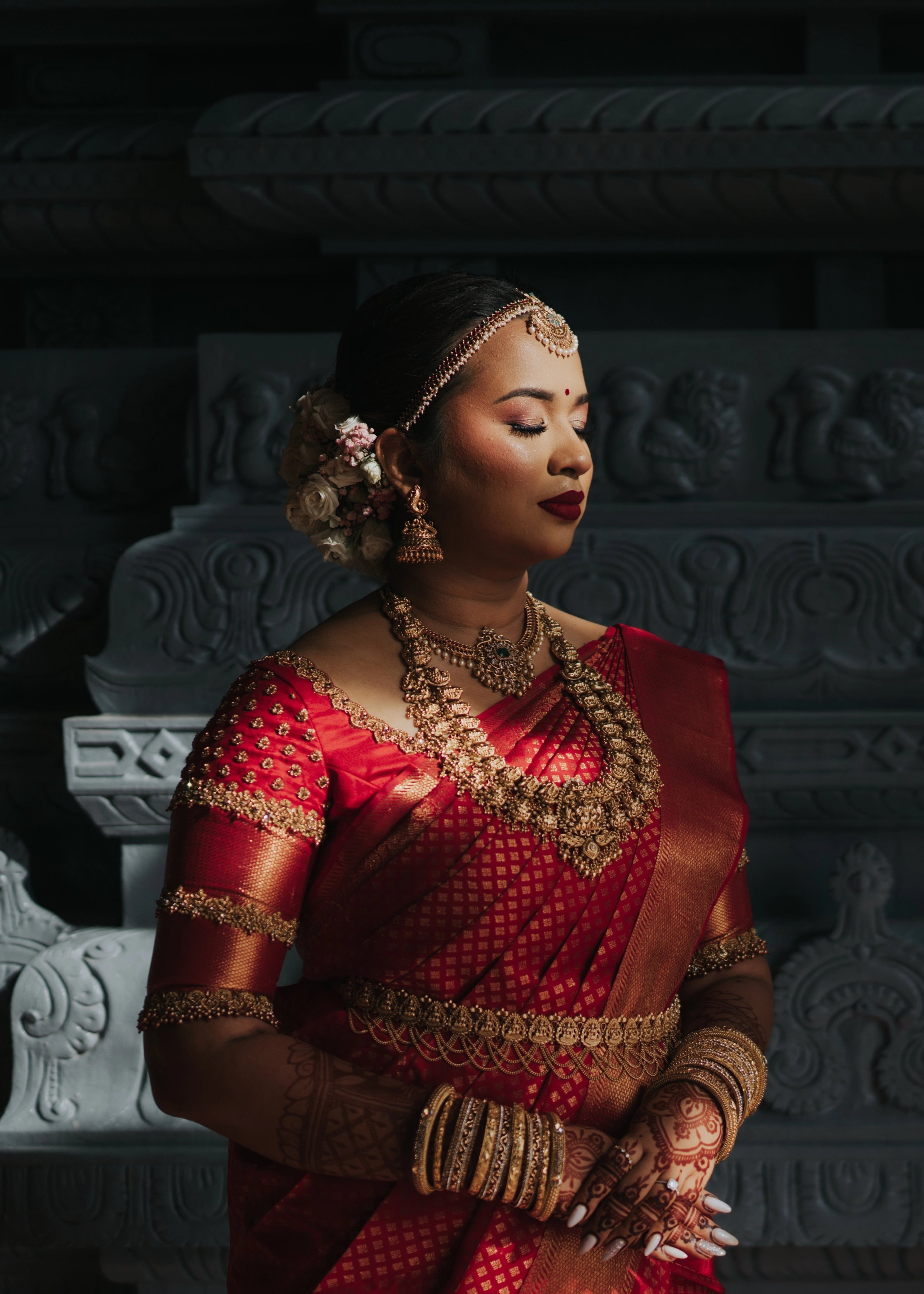 Bride reminiscing in a handcrafted palanquin concept red silk blouse features zardozi and beads. Designed by Archana Karthick.