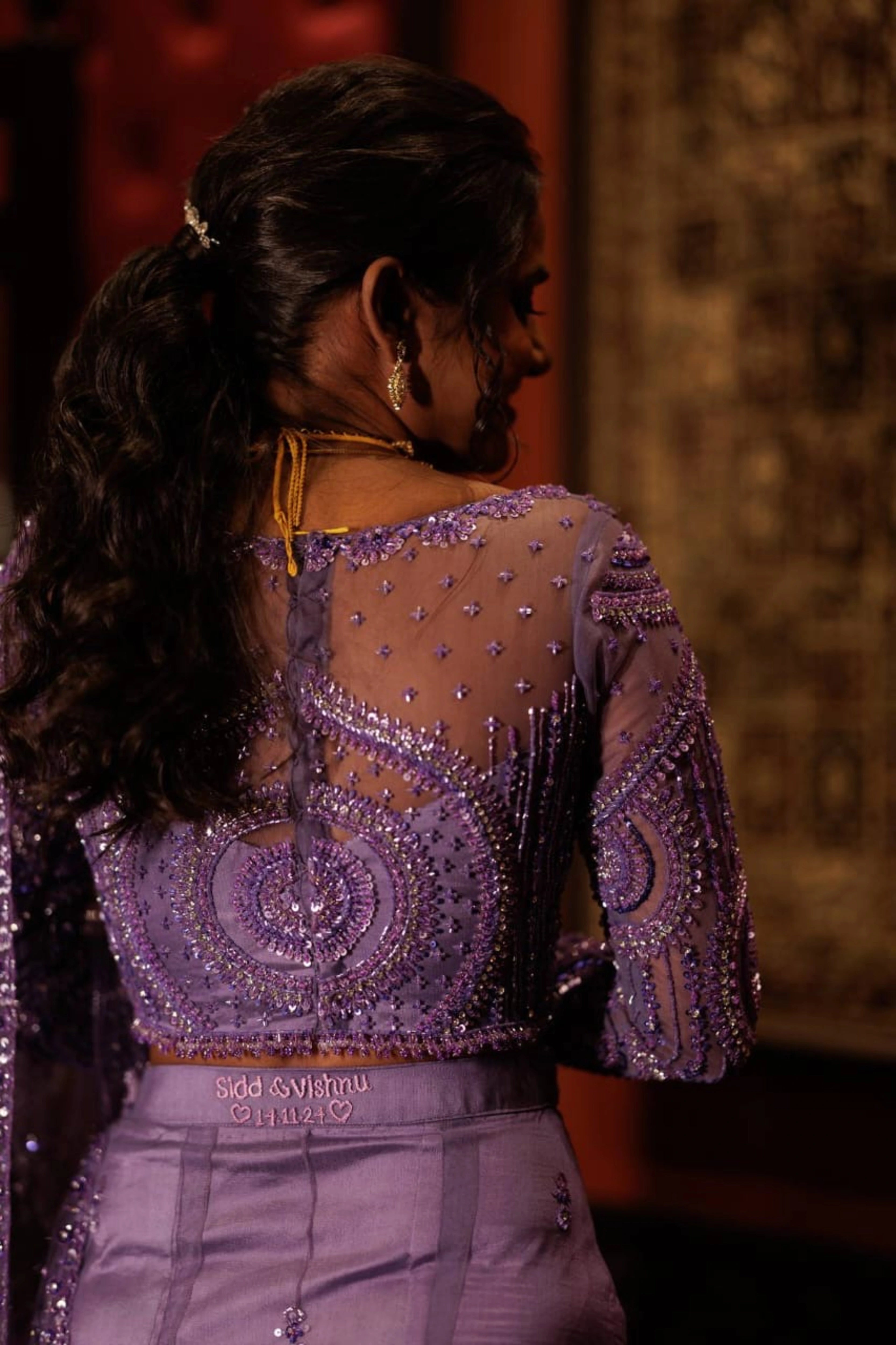 Bride Vishnu Karthika showcasing back design in a lavender tulle draped saree, handcrafted with rhinestones, zardozi, sequins, crystals, cutdana and resham by team Archana Karthick.