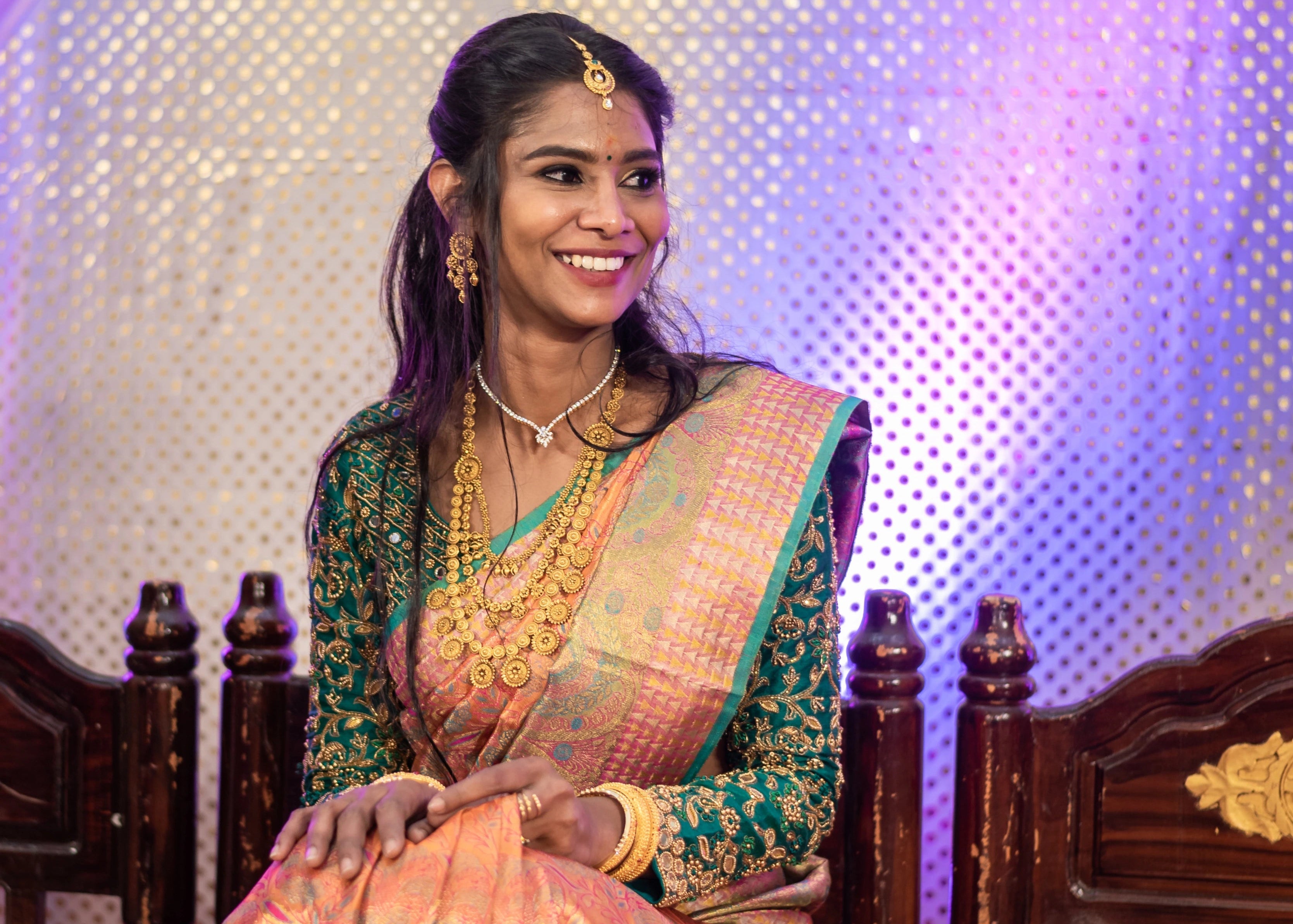 Bride smiling in full sleeves green blouse for her wedding rituals designed by Archana Karthick
