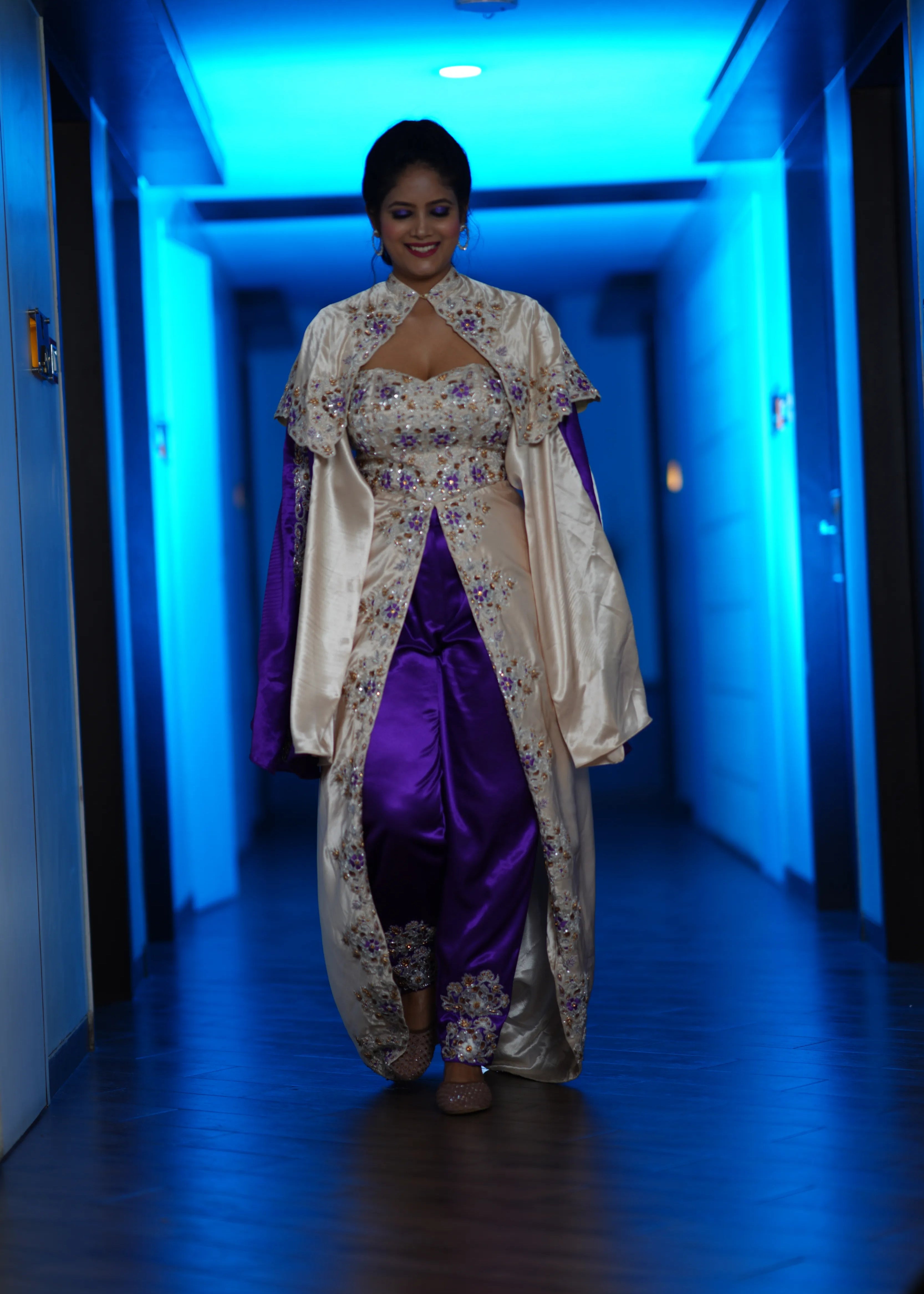 Bride walking in a handcrafted satin silk corset outfit (corset x masakali x kimono fusion) embellished with cut dana, sequins, beads and resham embellishments. This was designed for her sangeet party.