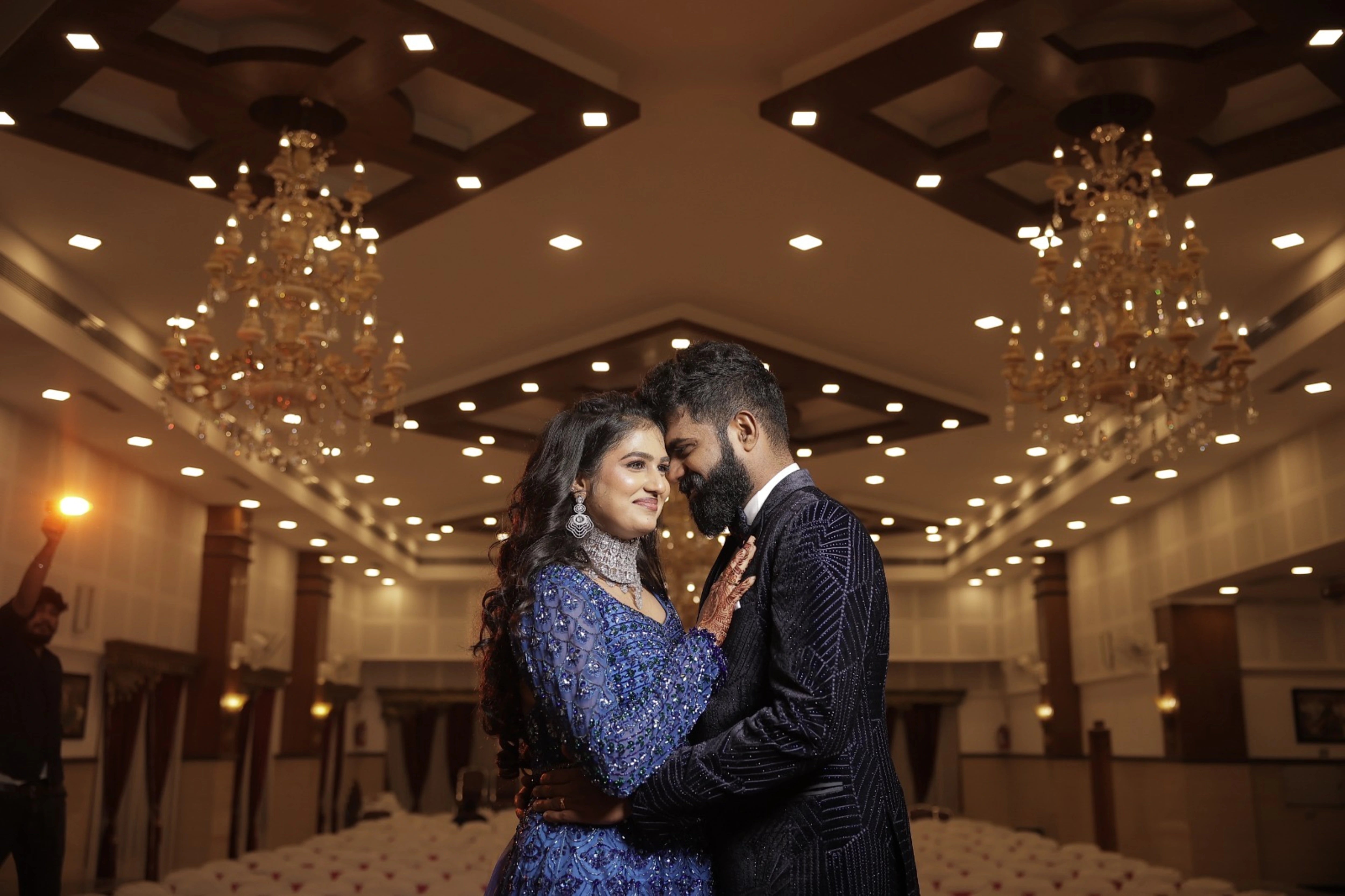 Bride Monishka with groom in a peacock themed blue ombre tulle lehenga, handcrafted with sequins, cutdana, rhinestones and feathers by team Archana Karthick.