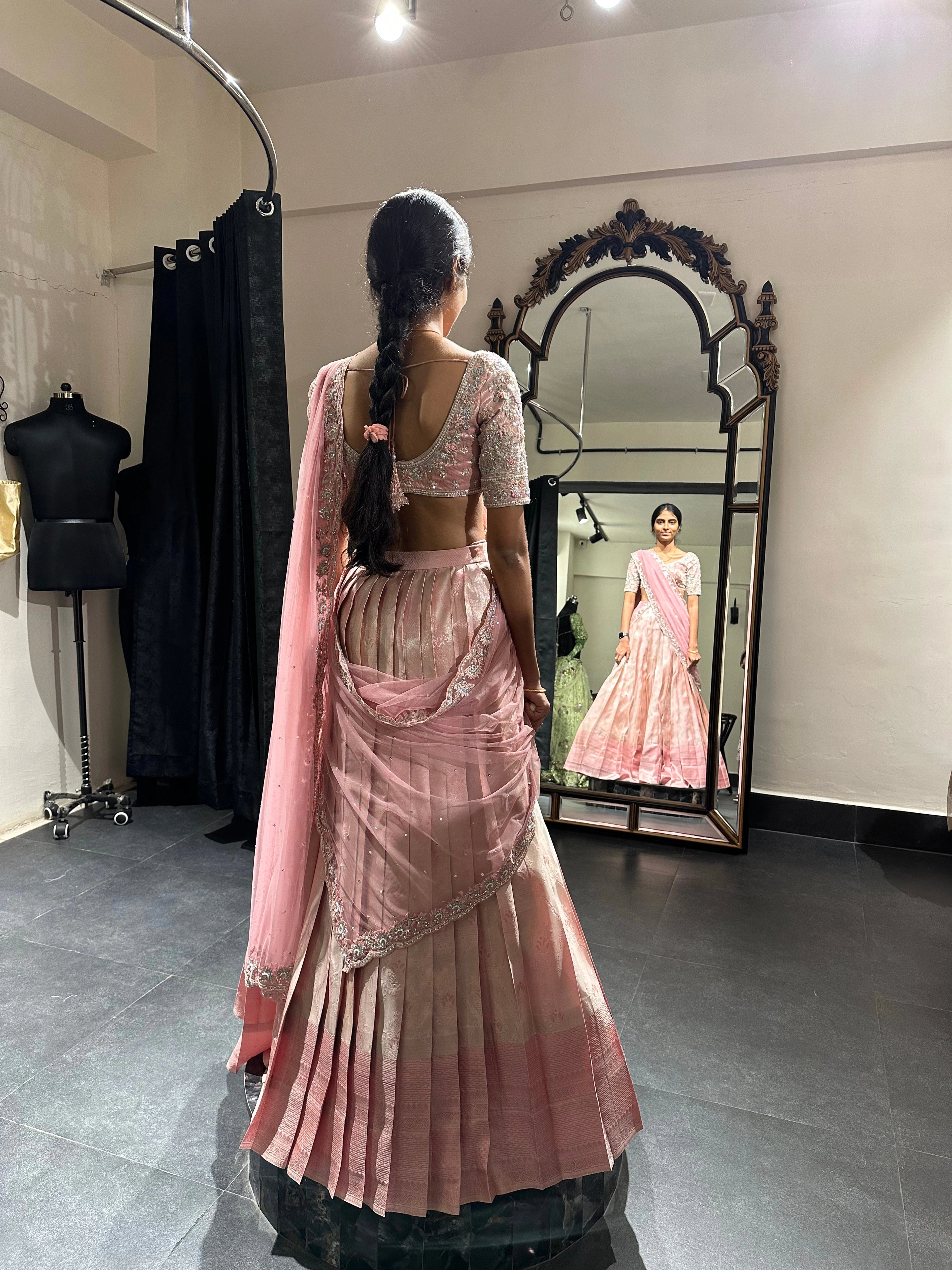 Bridesmaid Nirupama during fittings in an onion pink half saree, handcrafted by team Archana Karthick.