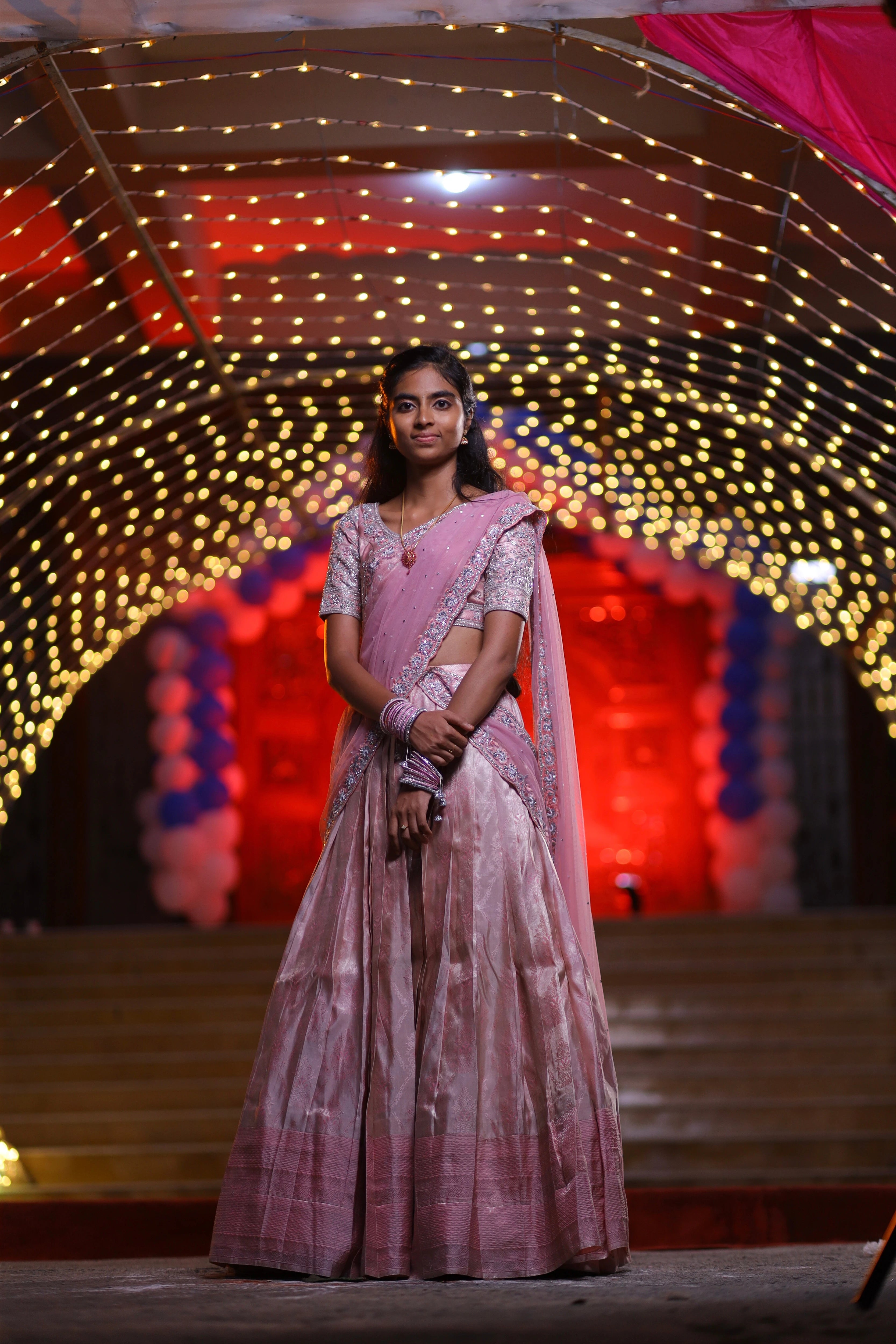 Bridesmaid Nirupama in an onion pink half saree, handcrafted by team Archana Karthick.