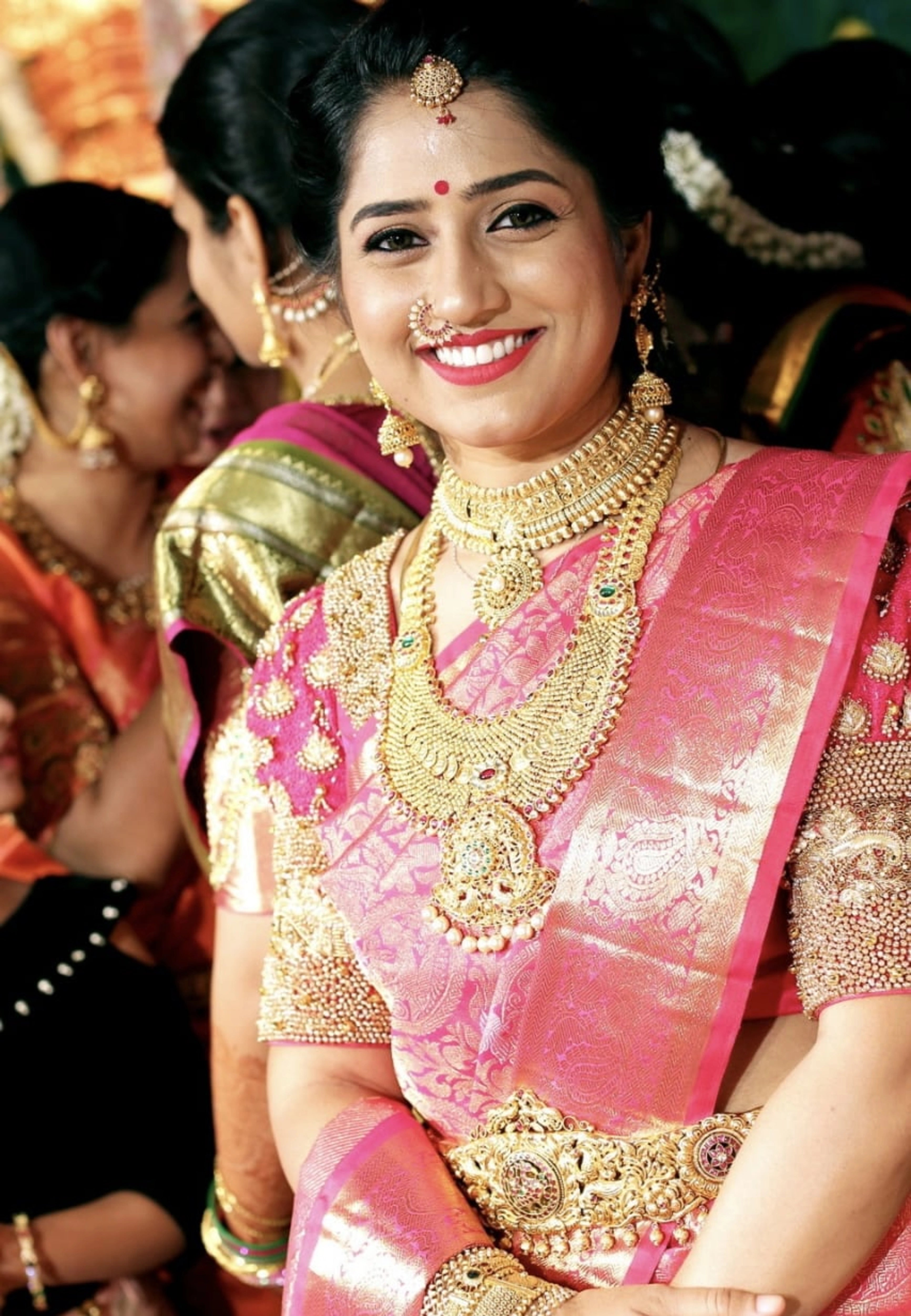 Bridesmaid Nivetha posing in a puff sleeved silk blouse, intricately handcrafted with zardozi, beads, resham knot work, beads, and ghungroos by team Archana Karthick.