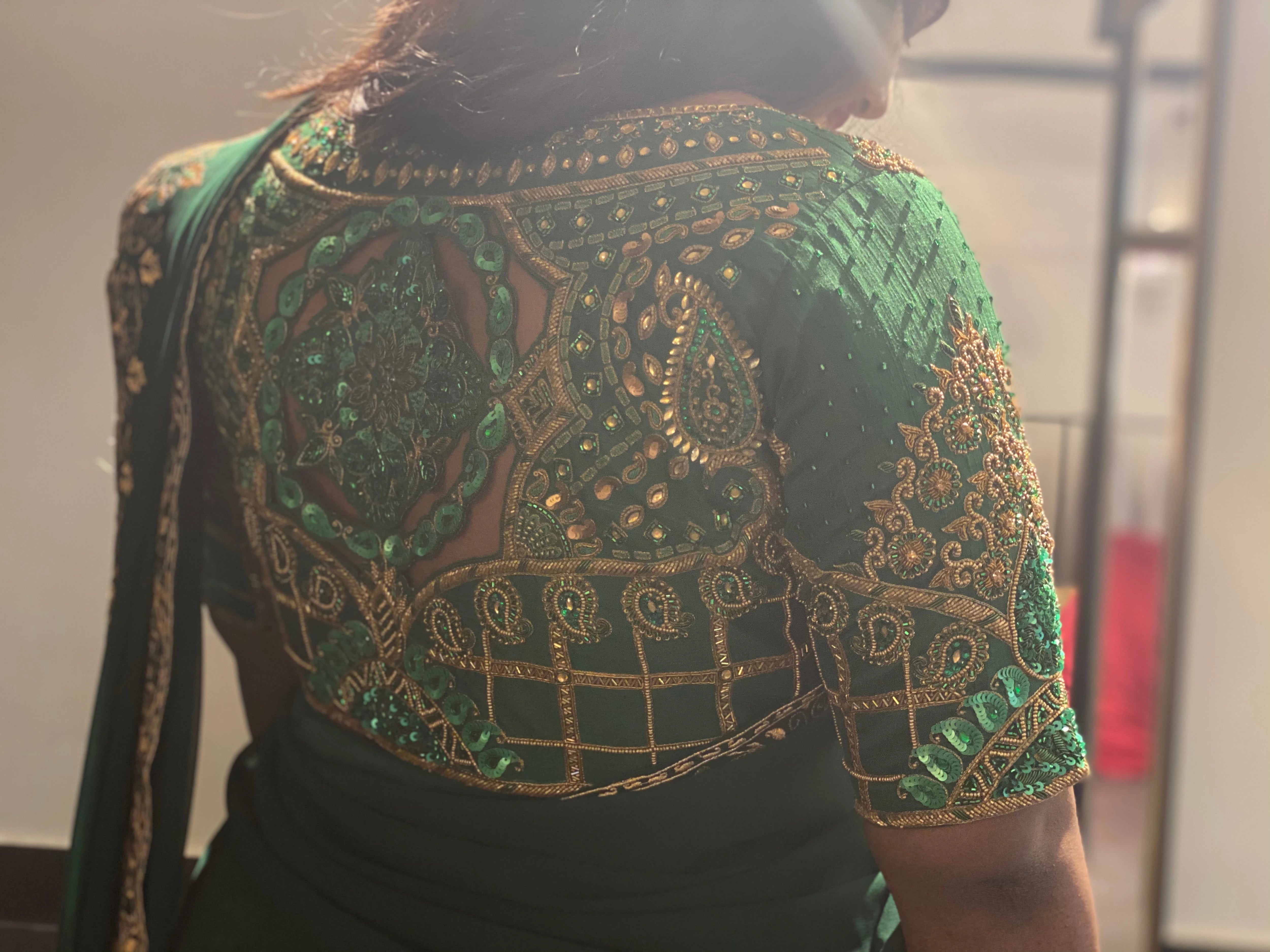 Bridesmaid Ramadevi during her fittings in a green silk blouse, handcrafted by team Archana Karthick.