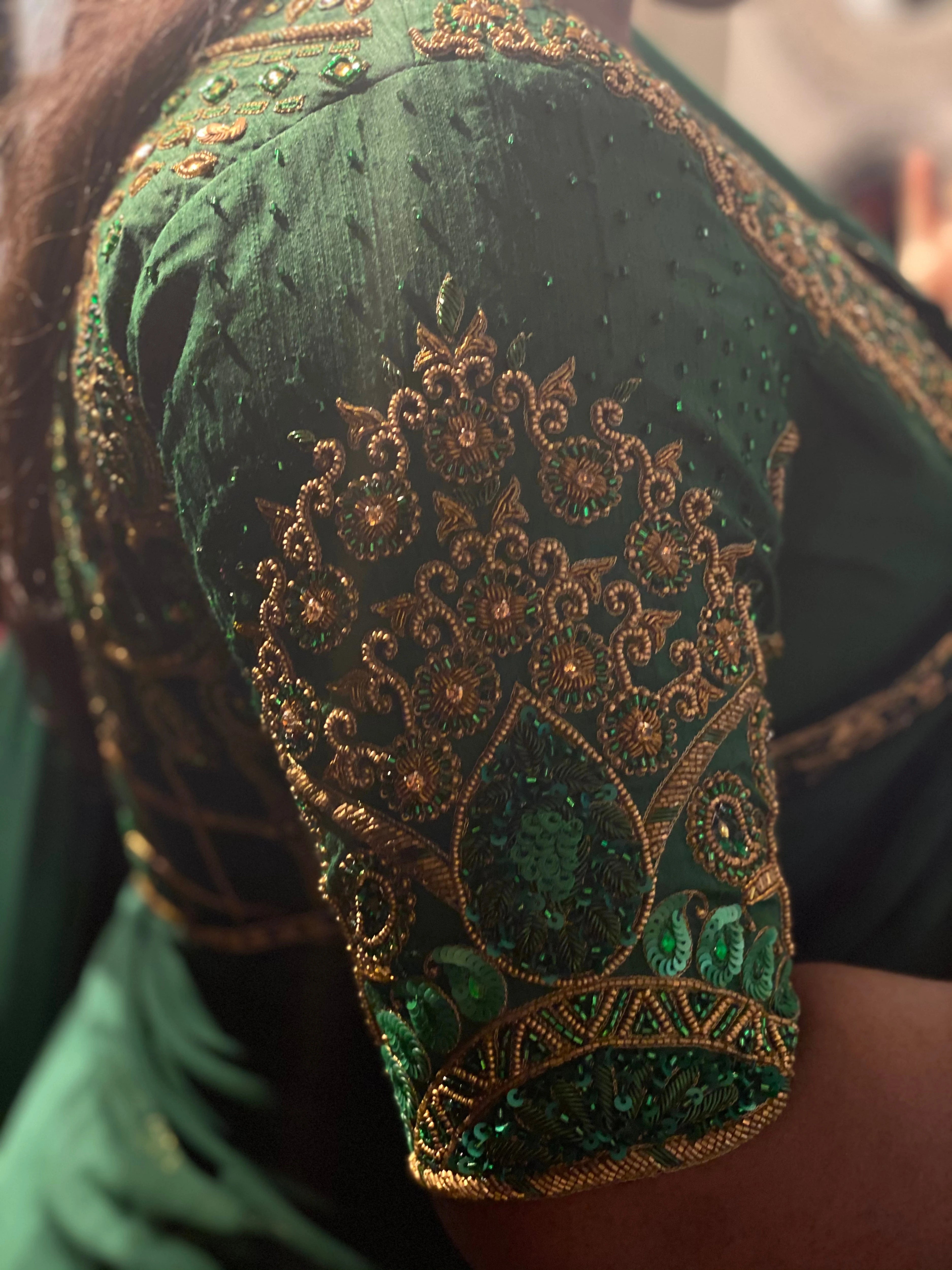 Bridesmaid Ramadevi in a green silk blouse, handcrafted by team Archana Karthick.