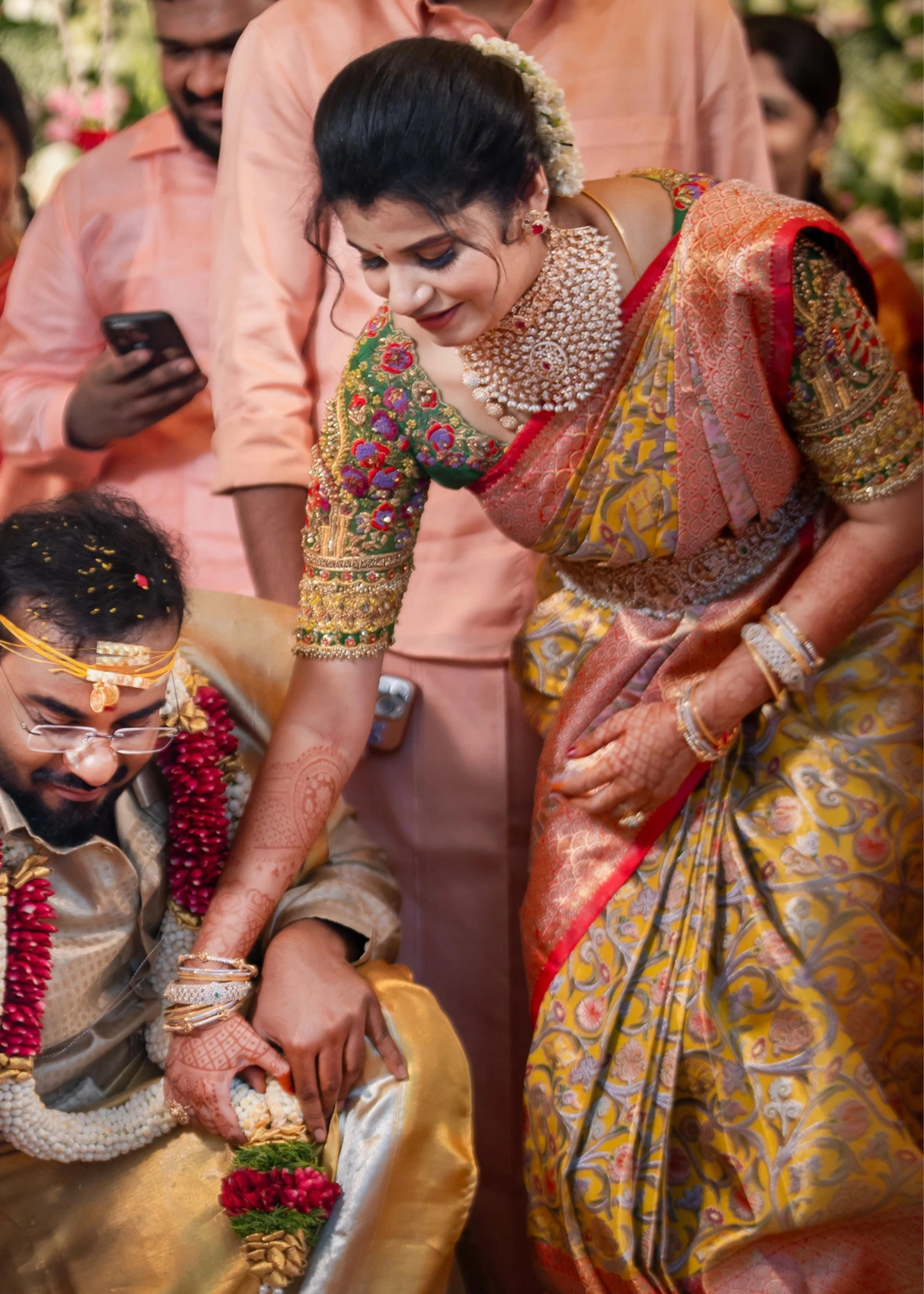 Bridesmaid Sanjana Sujith during ritual in a green silk blouse intricately handcrafted with resham, zardozi, sequins, beads, crystals and stones by Archana Karthick.