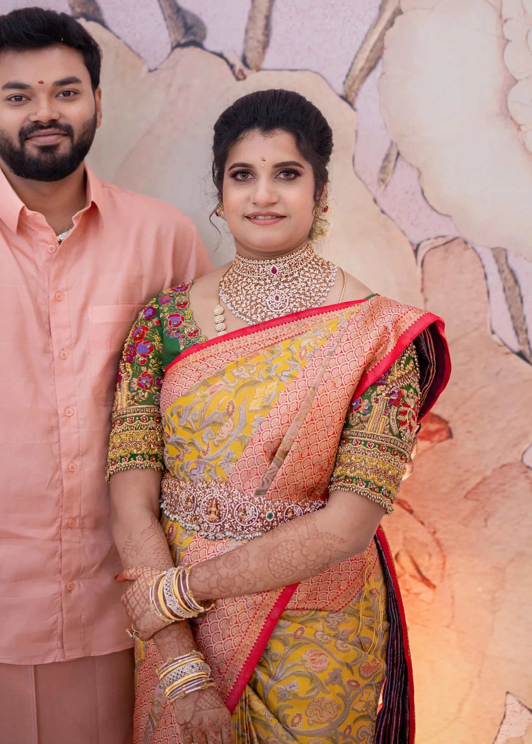 Bridesmaid Sanjana Sujith posing with groom in a green silk blouse intricately handcrafted with resham, zardozi, sequins, beads, crystals and stones by Archana Karthick.