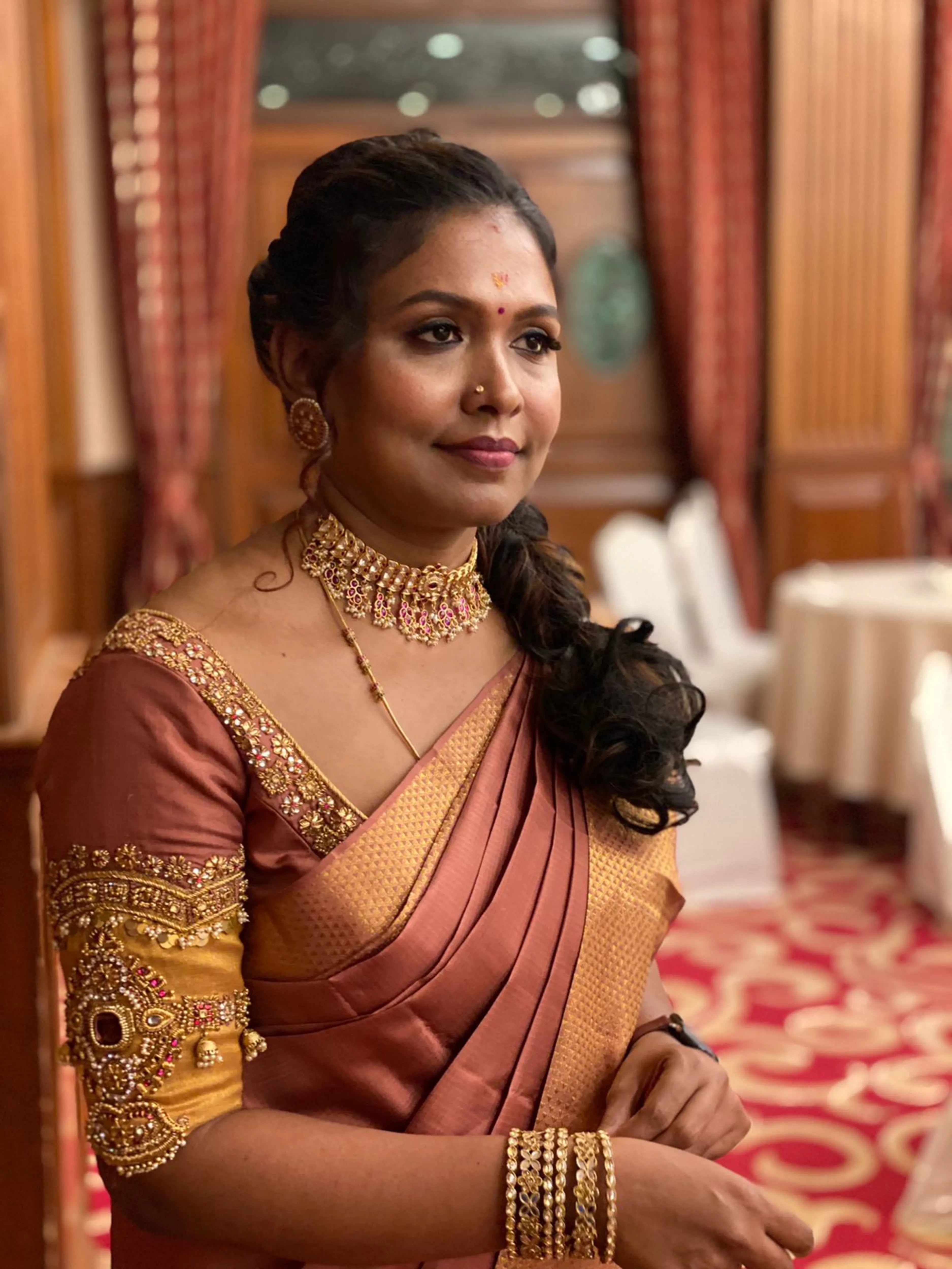 Bridesmaid Sasi smiling in a lilac silk blouse, handcrafted by team Archana Karthick.