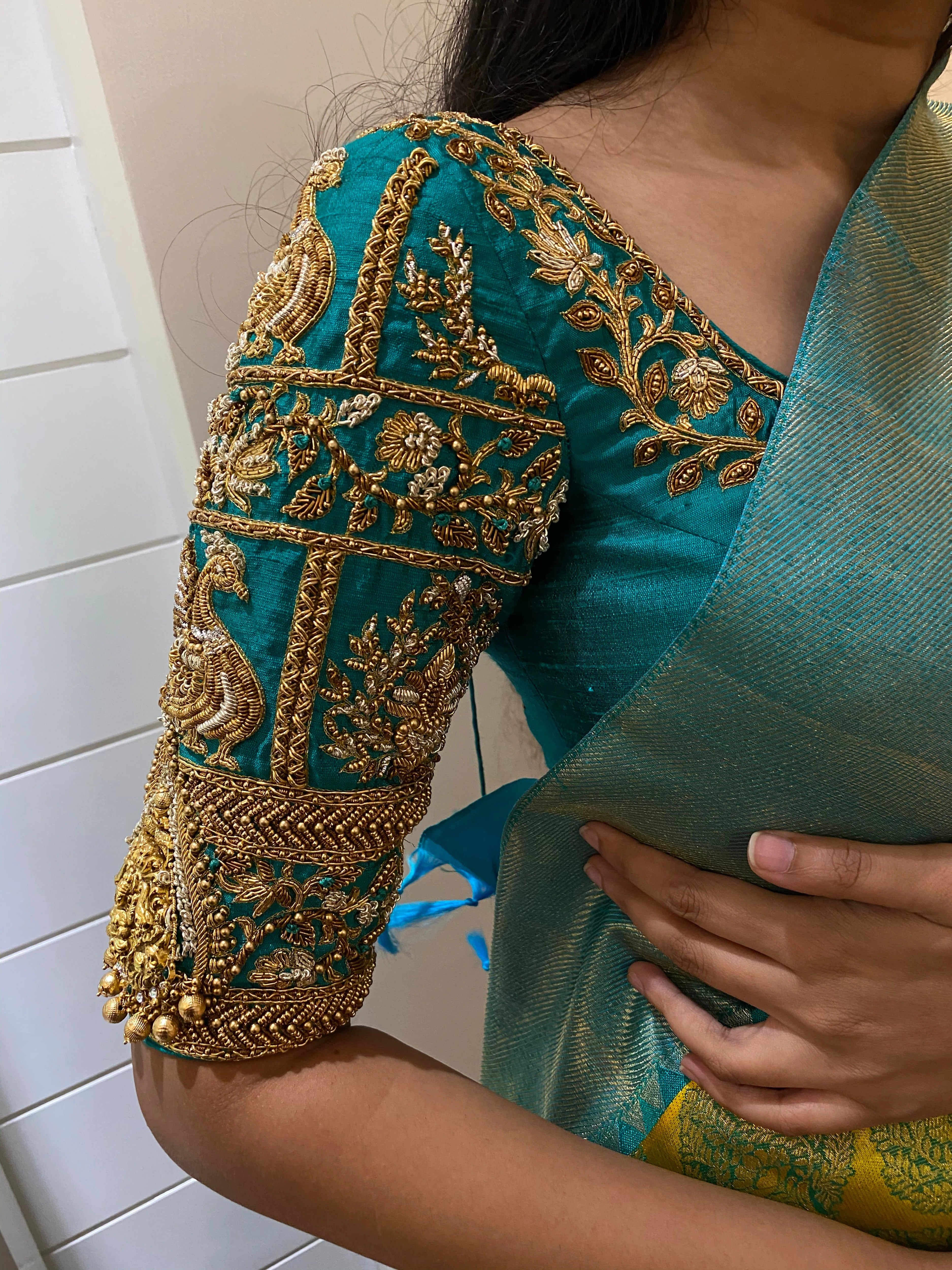 Bridesmaid Varsha during fittings in a teal silk blouse, handcrafted by team Archana Karthick.