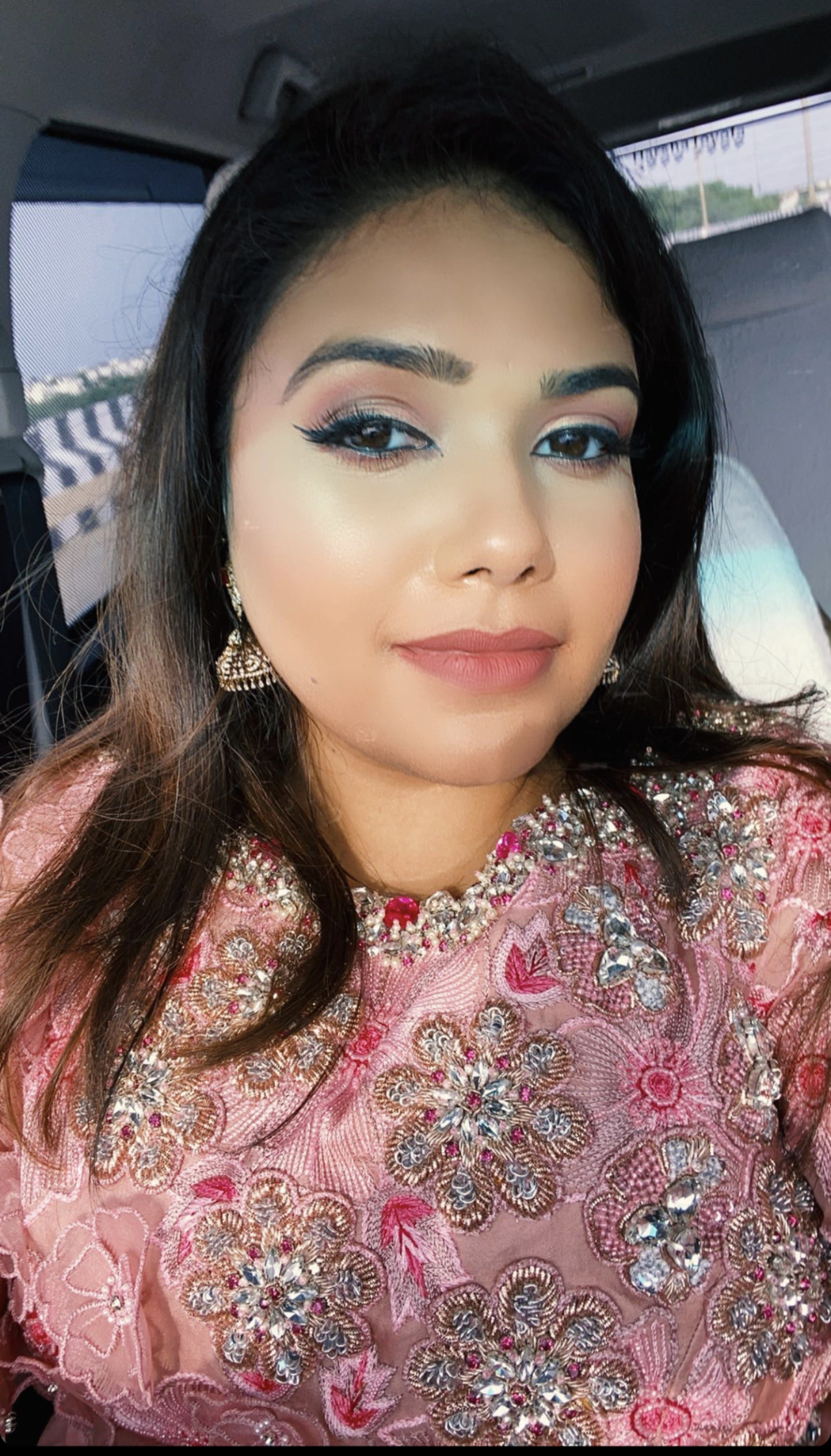 Bridesmaid from Chennai smiling in a pink organza gown handcrafted intricately with zardozi, stones, pearls and 3D floral appliques designed by Archana Karthick.