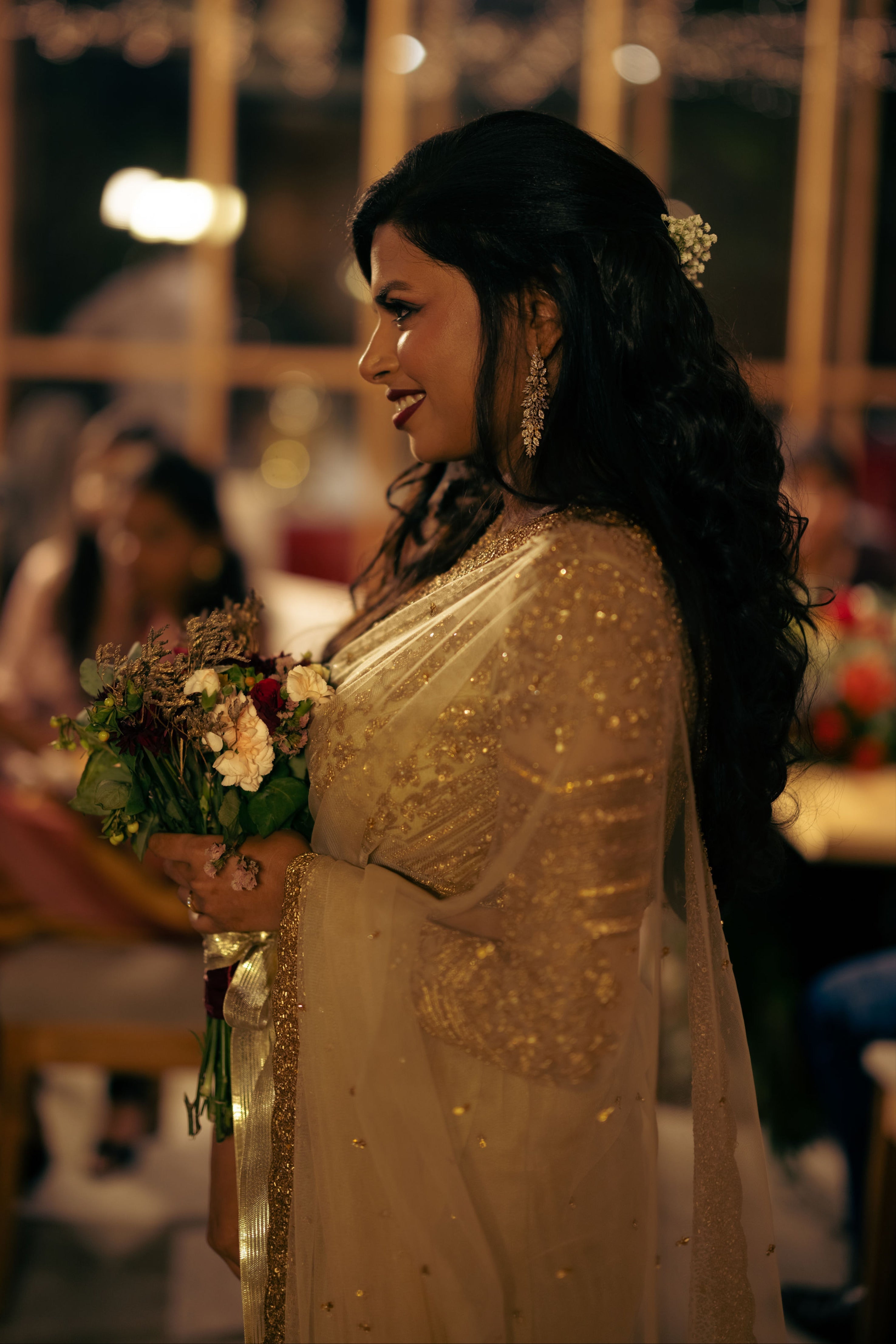 Christian Bride Steffi in handcrafted net saree in champagne gold designed by Archana Karthick. Posing for side profile where sleeves are clearly seen.
