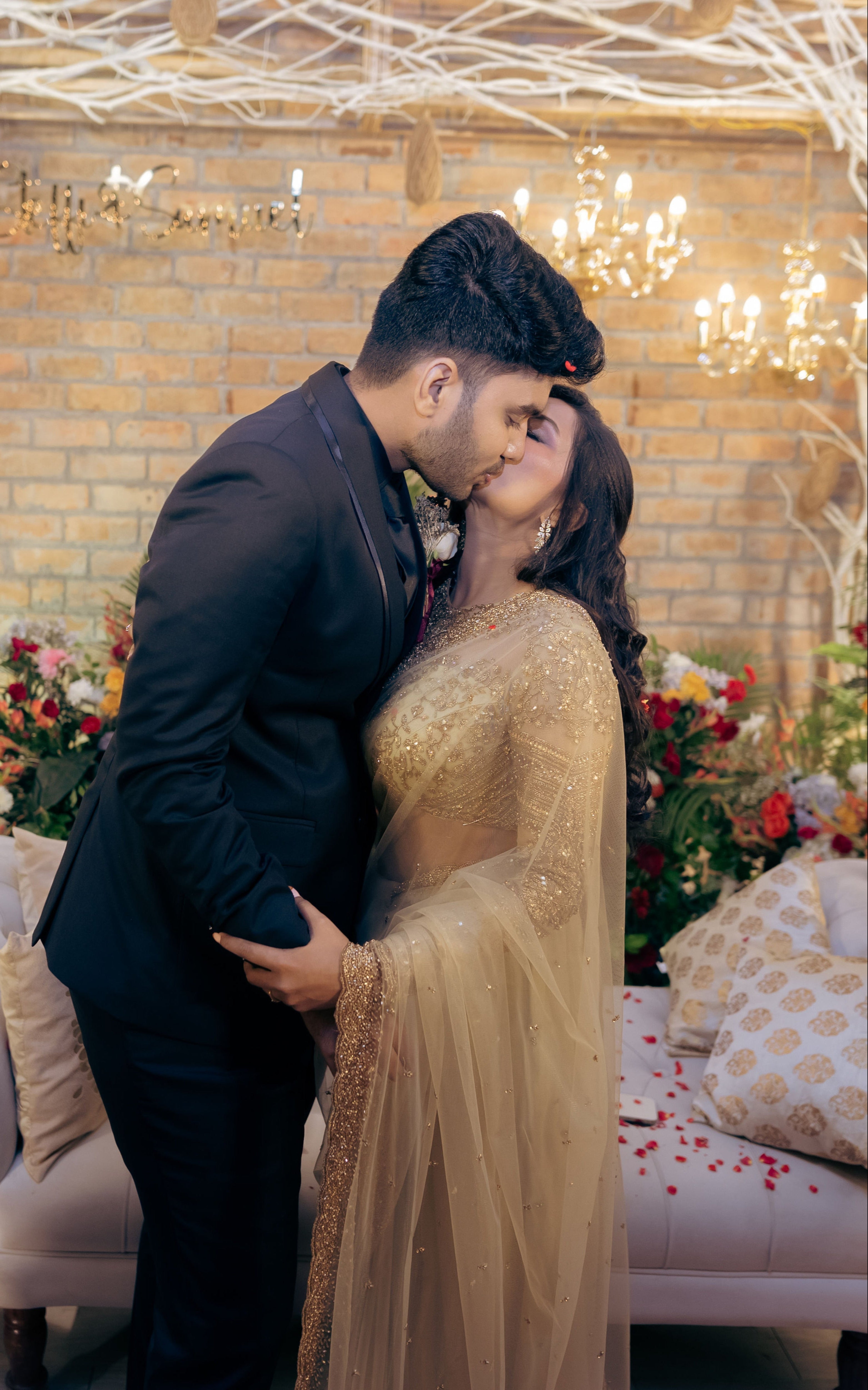 Christian Bride Steffi in handcrafted net saree in champagne gold designed by Archana Karthick. Posing intimately with her groom for a full front profile.