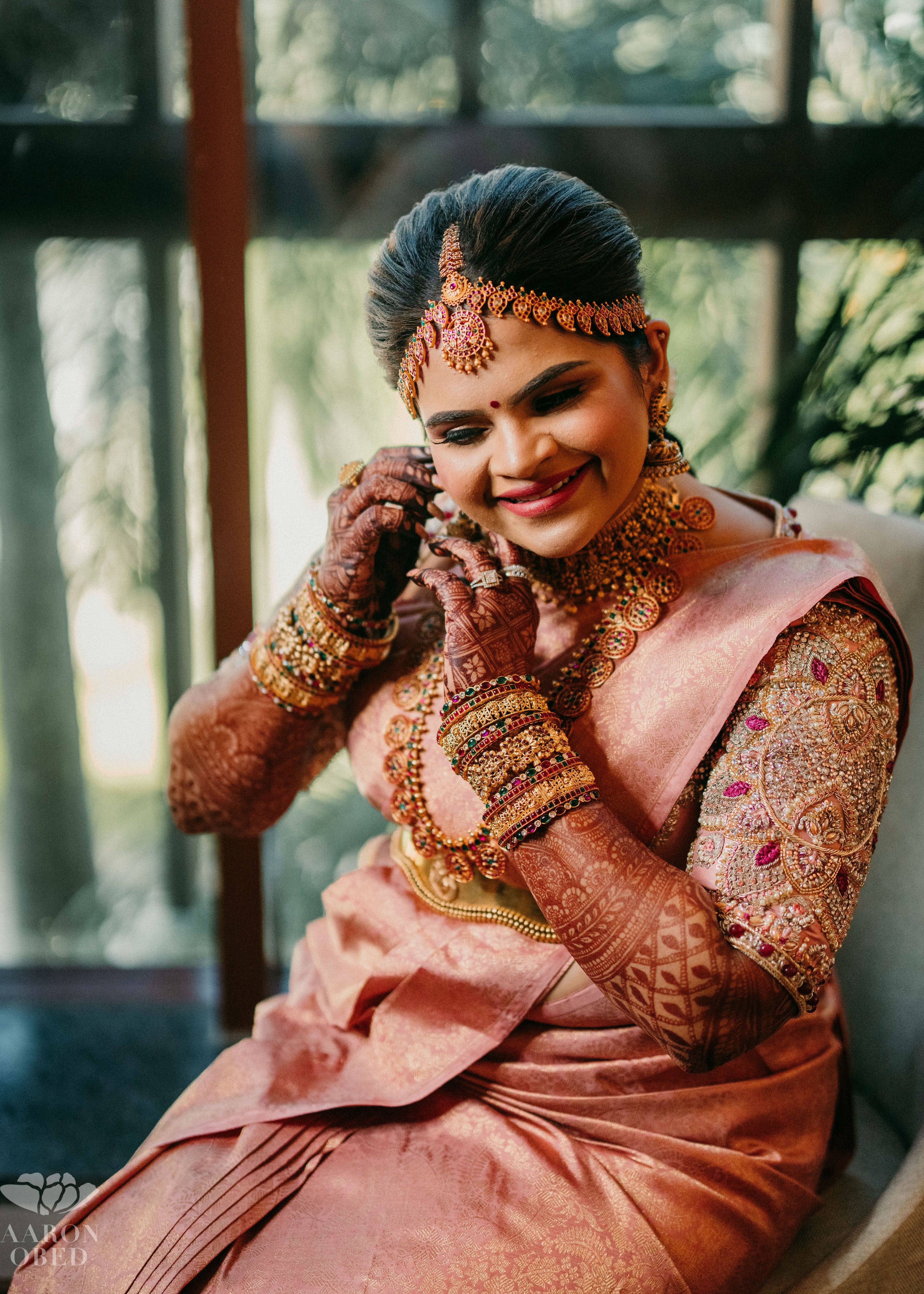 Comedian and actress Vidyu Raman laughing in a palanquin concept pink blouse handcrafted intricately with resham knot work, cut dana, crystal, pearls, swarovski stones and sequins designed by Archana Karthick.