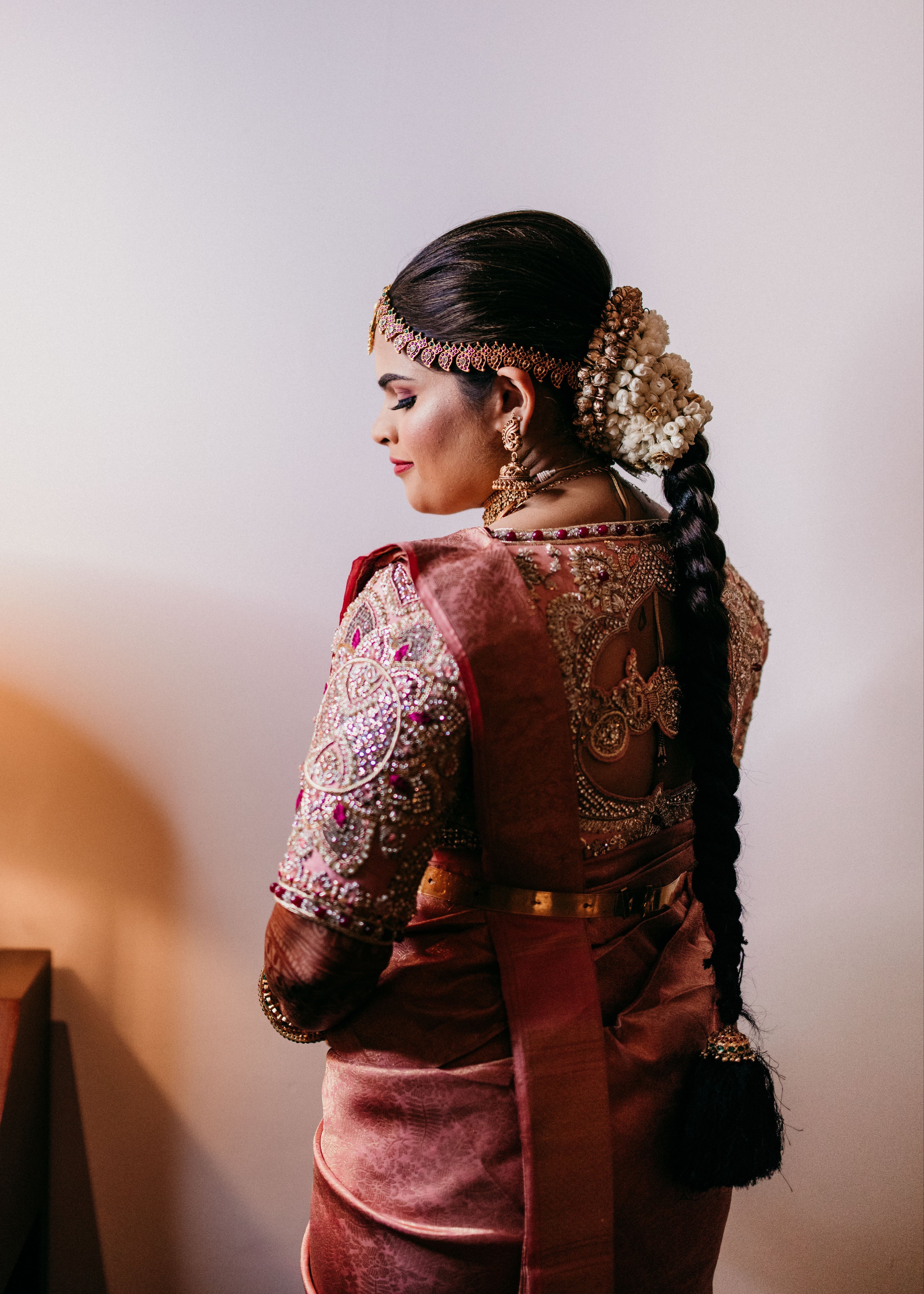 Comedian and actress Vidyu Raman posing in a palanquin concept pink blouse handcrafted intricately with resham knot work, cut dana, crystal, pearls, swarovski stones and sequins designed by Archana Karthick.