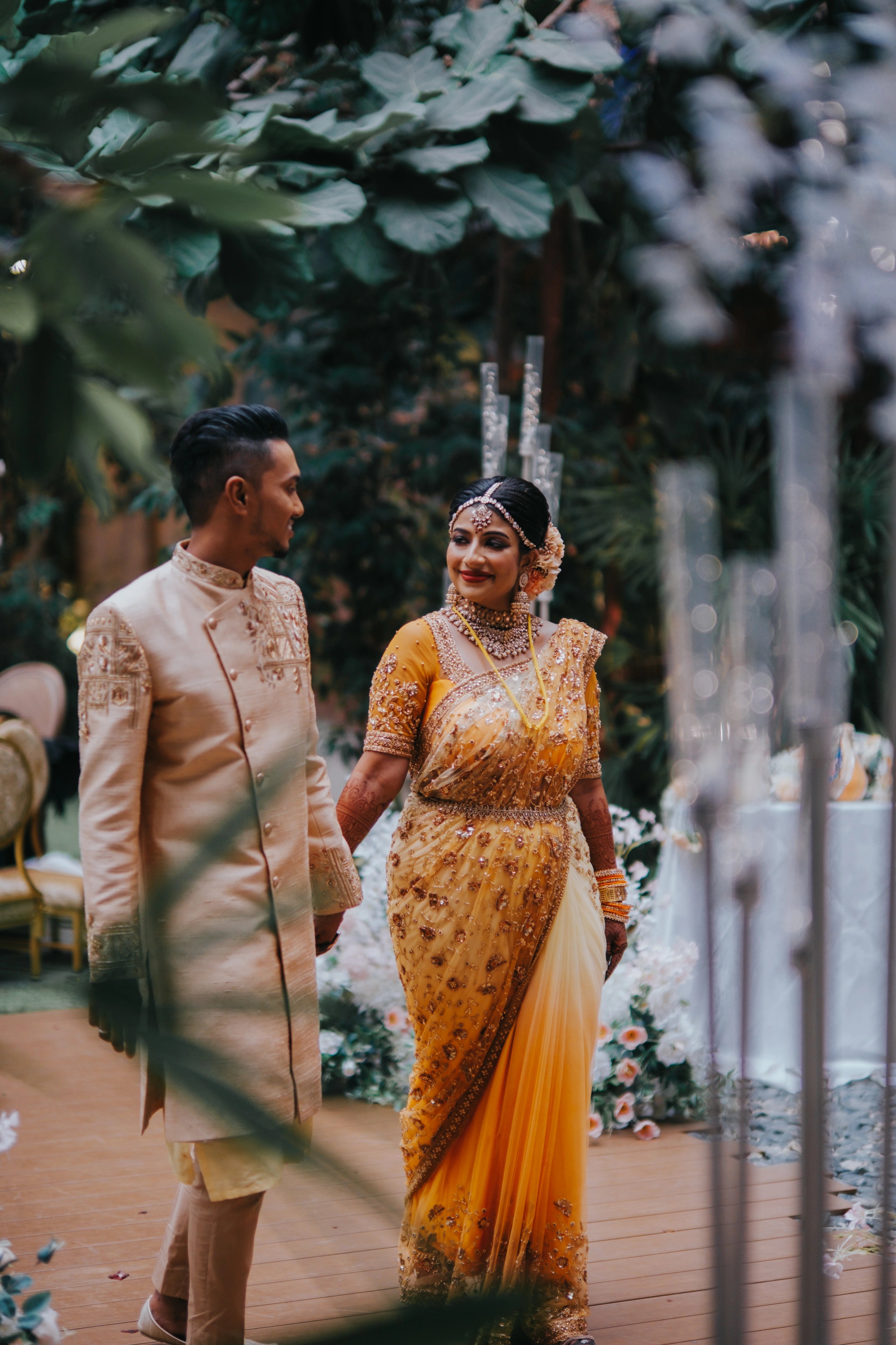 Couple from Malaysia smiling, in a sherwani handcrafted by team Archana Karthick.