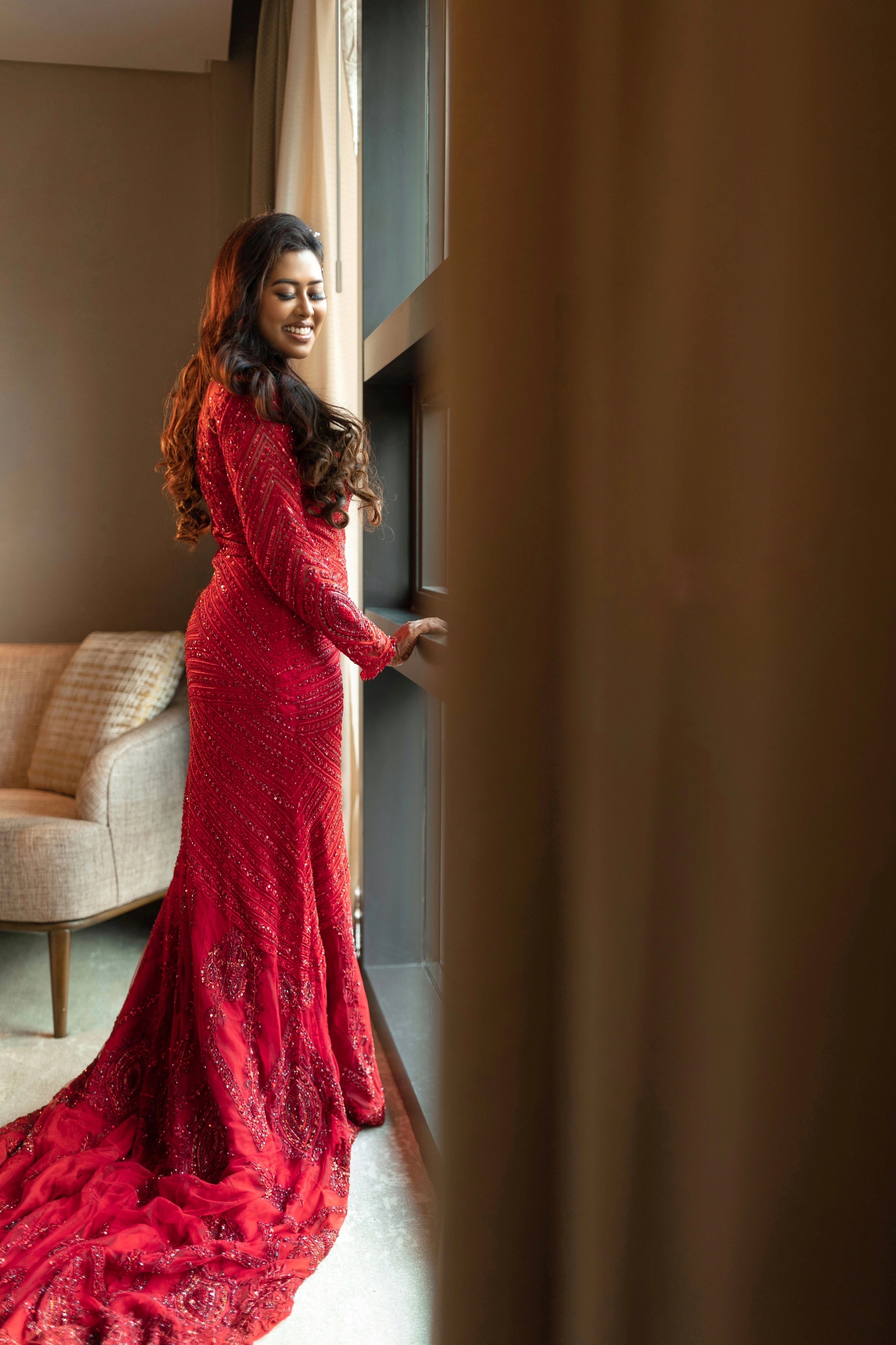 Dr Vishu Priya in a ruby red mermaid gown intricately handcrafted by team Archana Karthick.