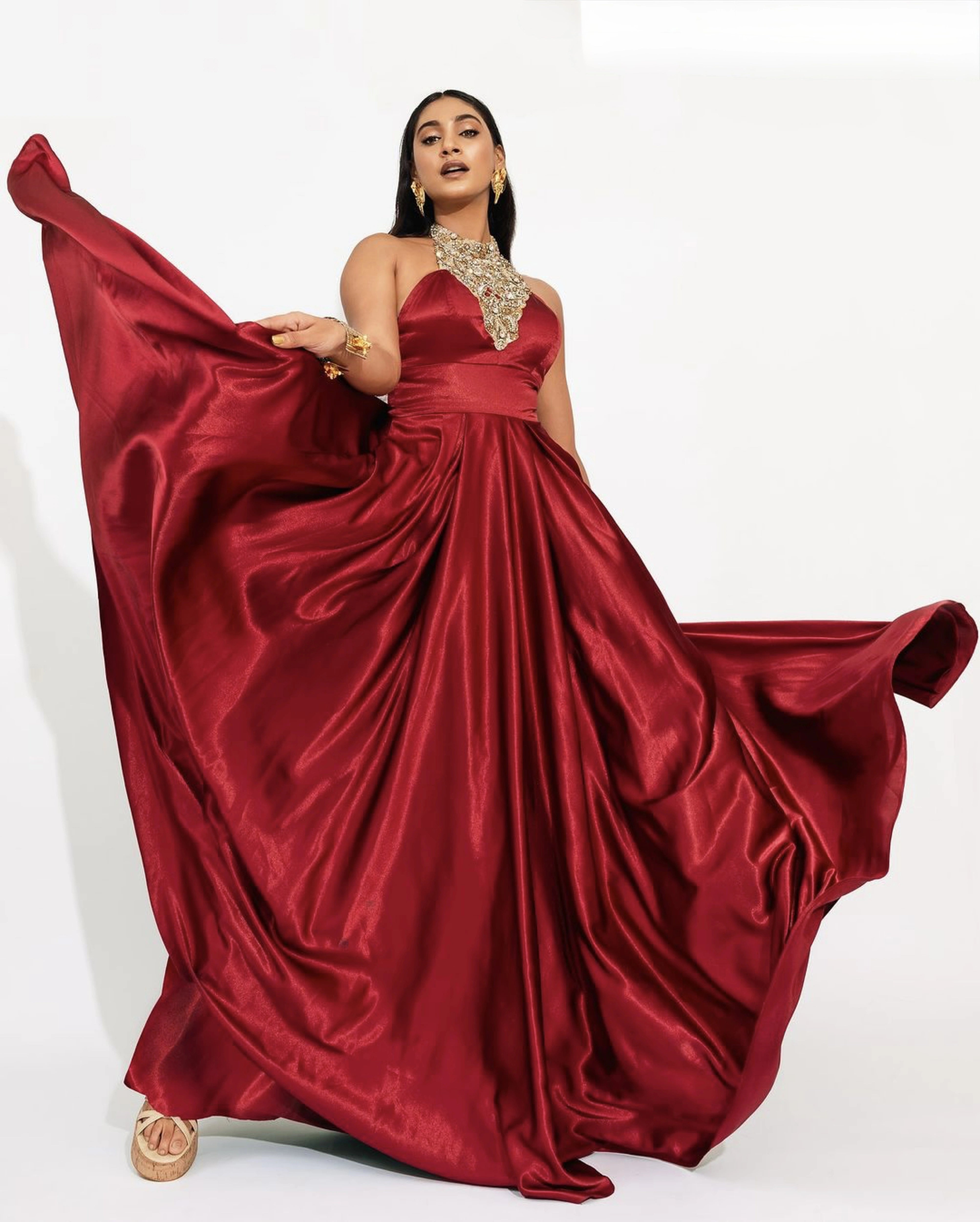 Former Miss India and Actress Anukreethy Vas in a red satin silk bejewled halterneck gown by team Archana Karthick.