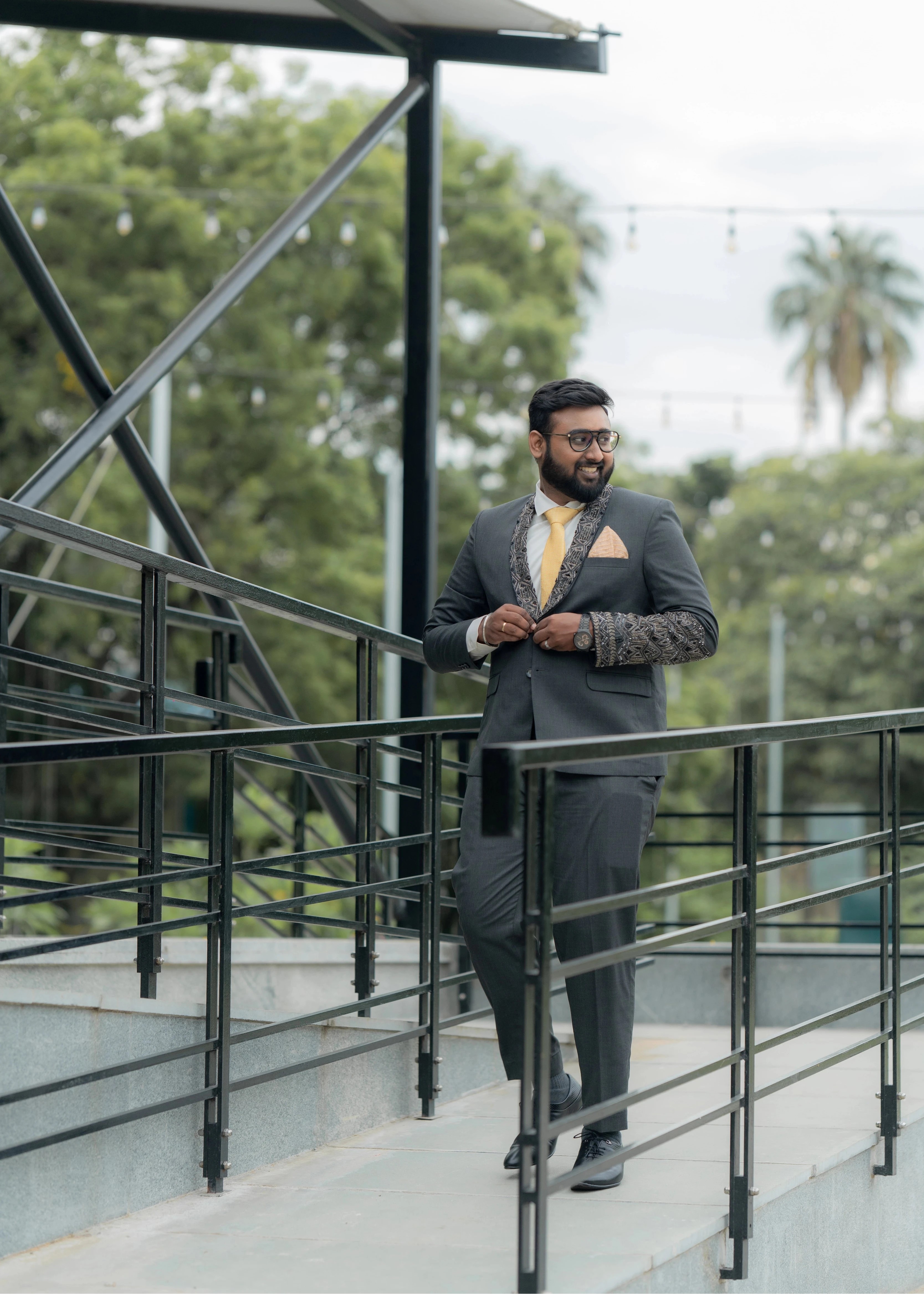 Groom Jai in a bespoke charcoal grey suit, with lapels intricately handcrafted with beads and sequins by team Archana Karthick.