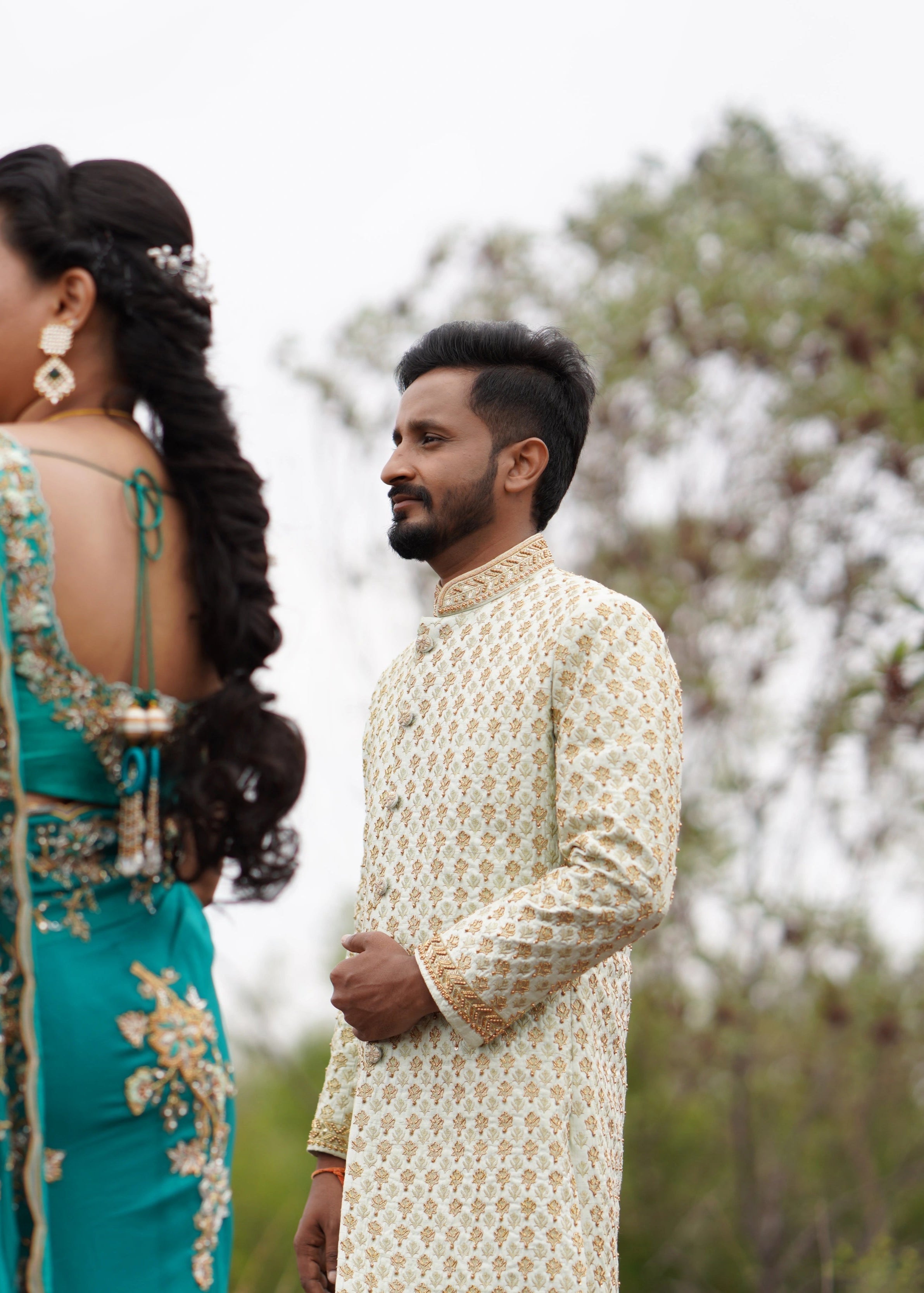 Groom from Seatlle, in a sage green sherwani designed in raw silk for a photoshoot is handcrafted intricately with zardozi, beads and zari. Designed by Archana Karthick.