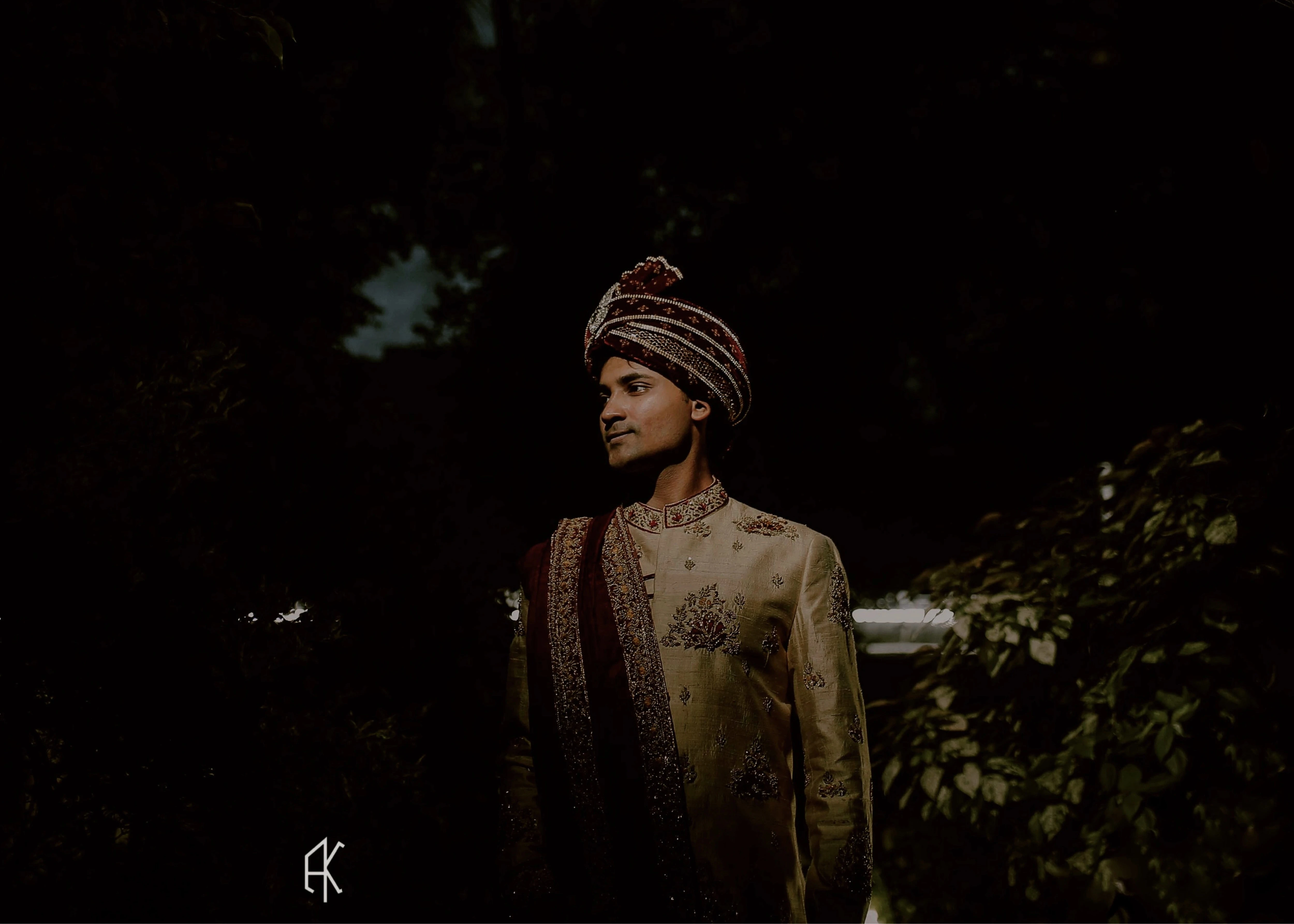 Groom smiling in a gold raw silk sherwani, intricately handcrafted with sequins, beads, resham, zardozi by team Archana Karthick.