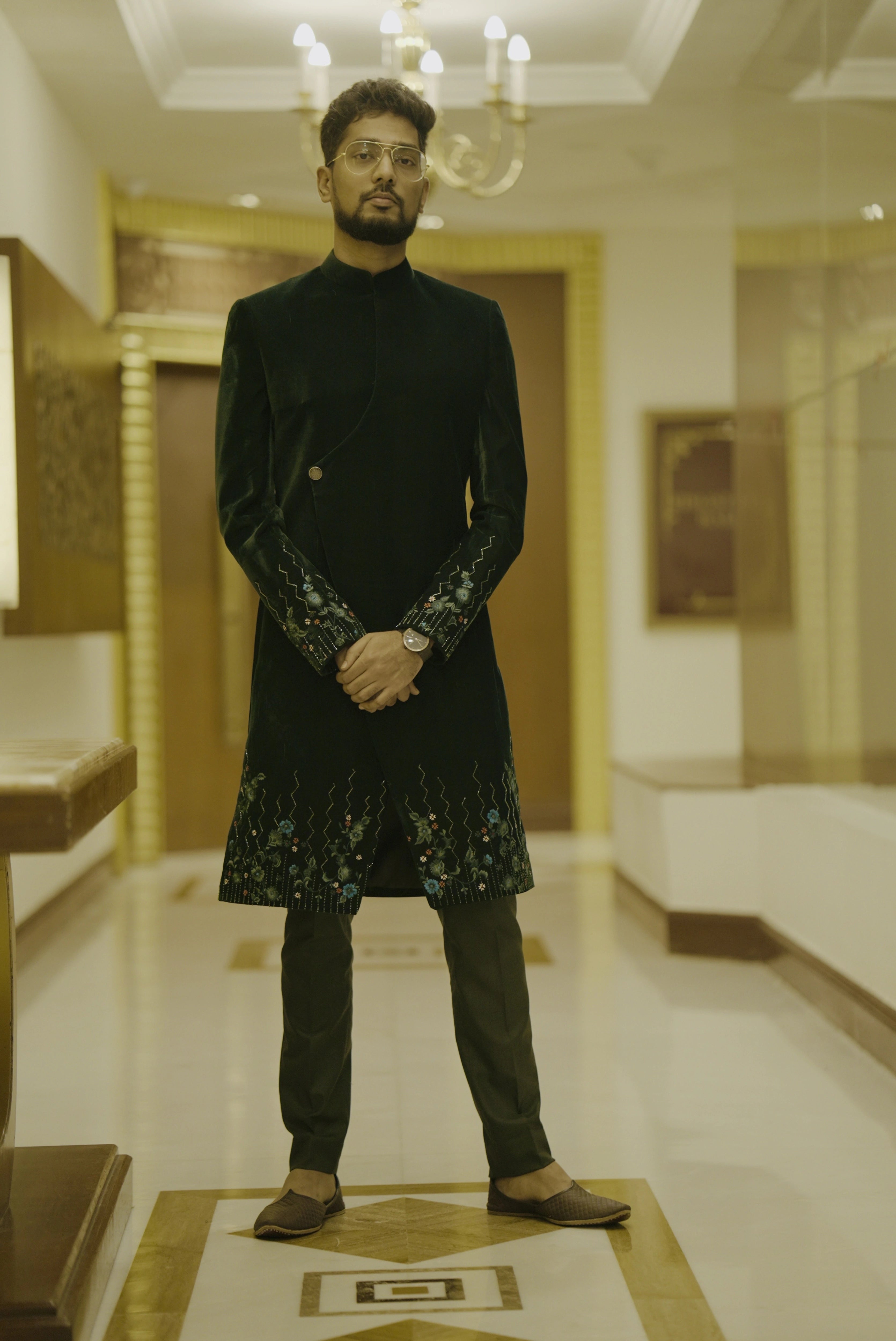 Groomsman Mahesh from Bangalore in a bottle green velvet sherwani handcrafted by team Archana Karthick.