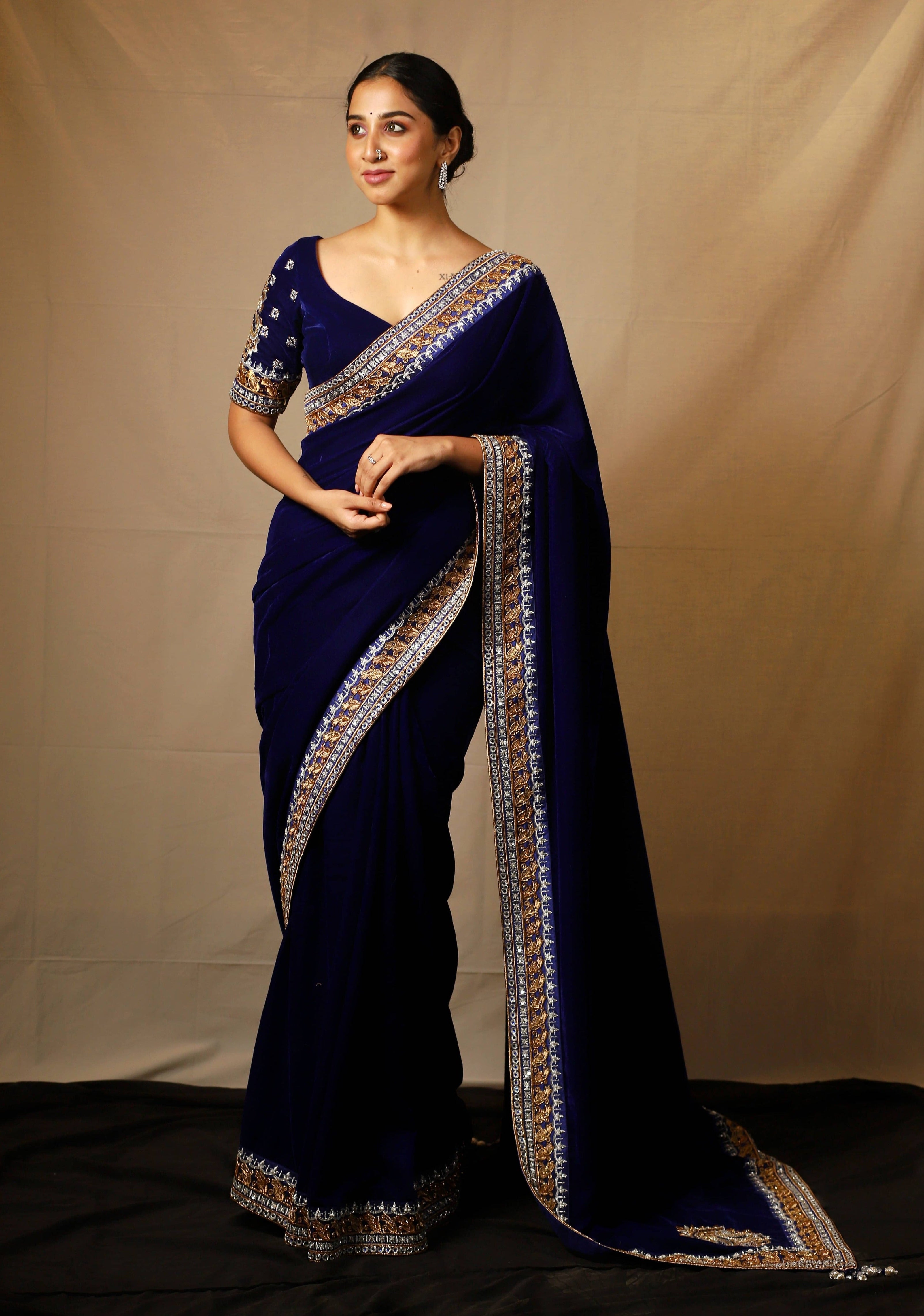 Influencer Deekshita Nikkam in a navy velvet saree and blouse set with zardozi detailings on border and sleeves.