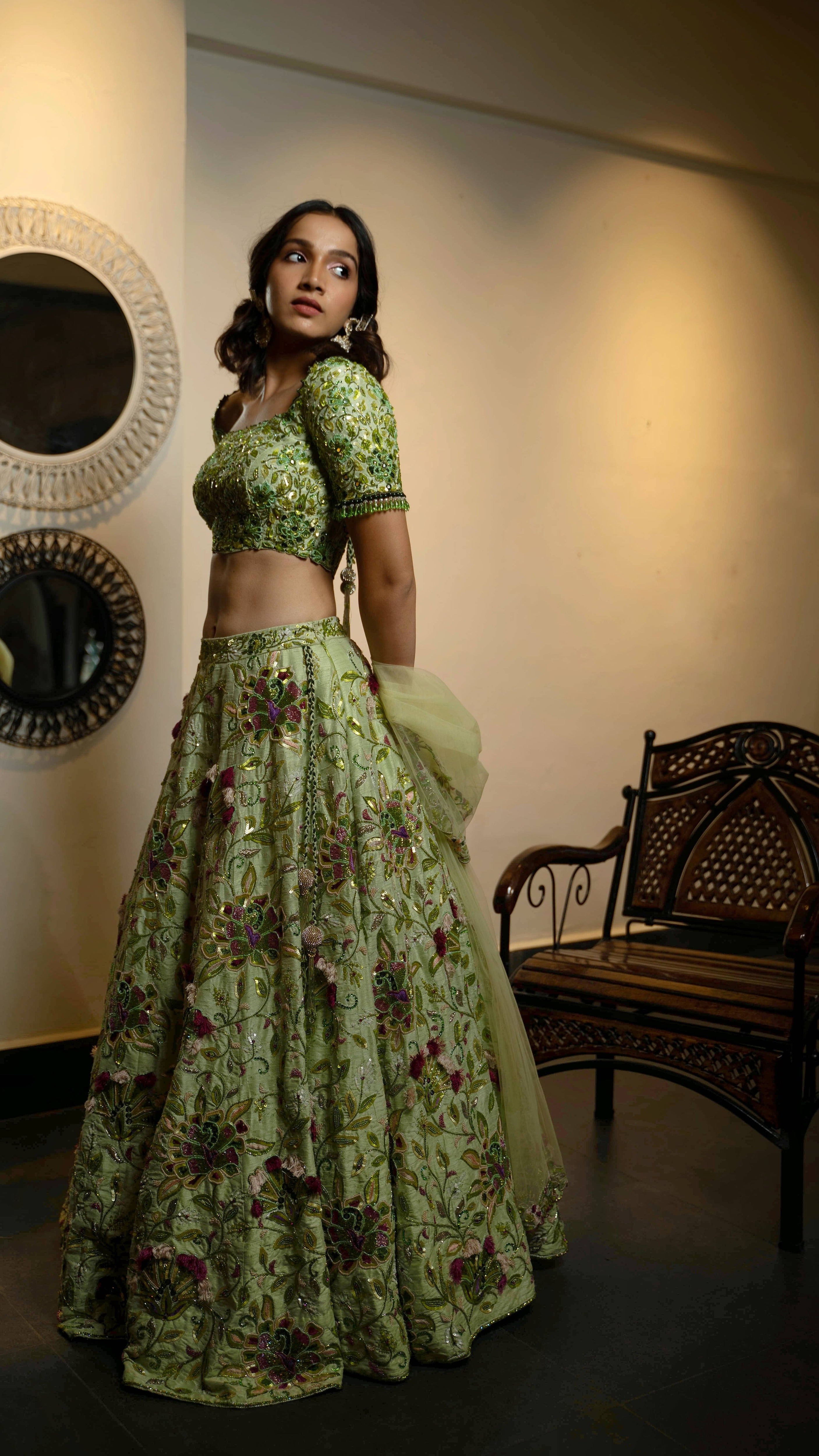 Influencer and actress Shweta Gai in a handcrafted green raw silk lehenga with floral motifs by Archana Karthick. Posing with dupatta in her hand and looking to her left.