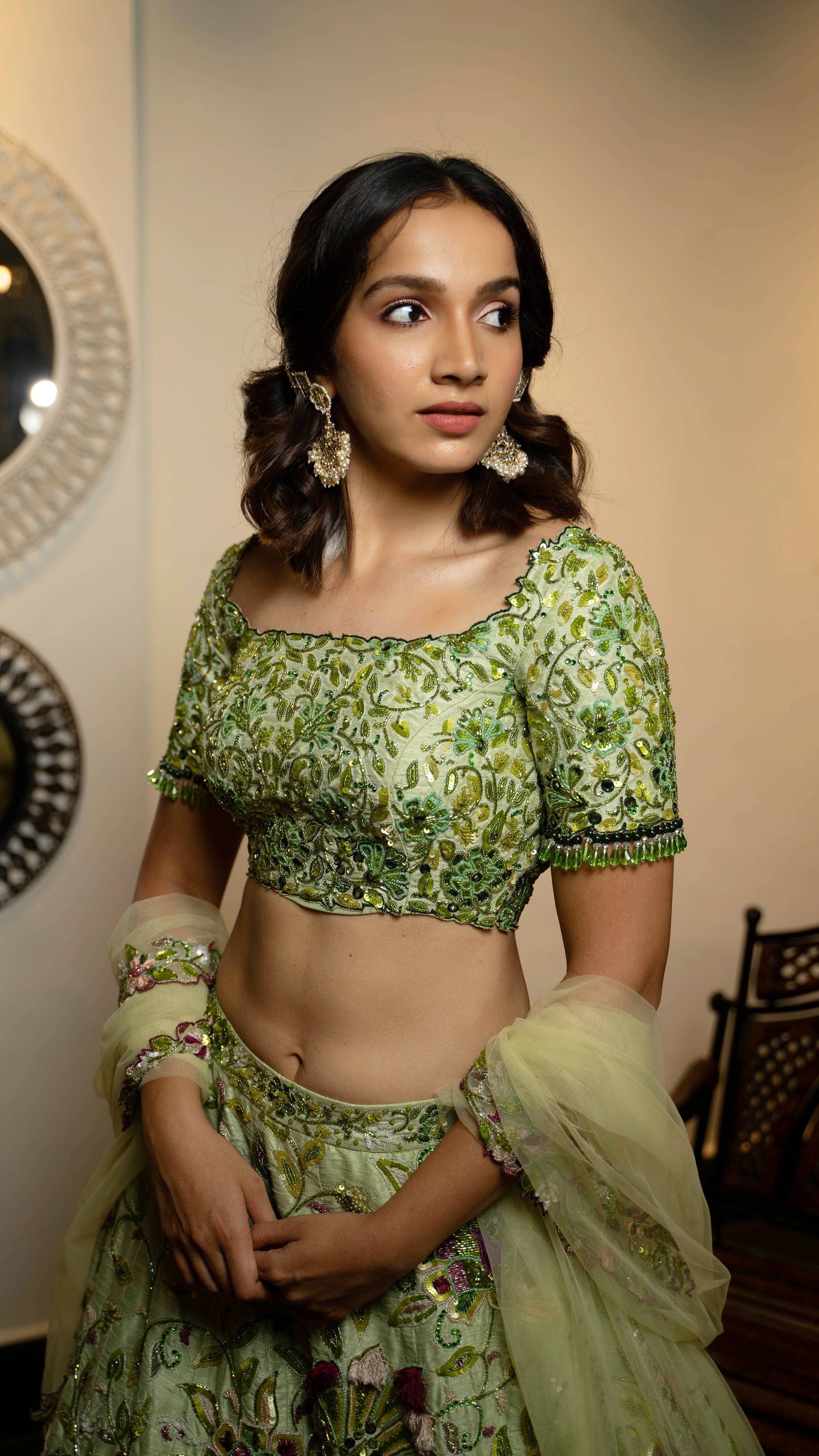 Influencer and actress Shweta Gai in a handcrafted green raw silk lehenga with floral motifs by Archana Karthick. Posing with dupatta wrapped around her hands and showing the front blouse design.