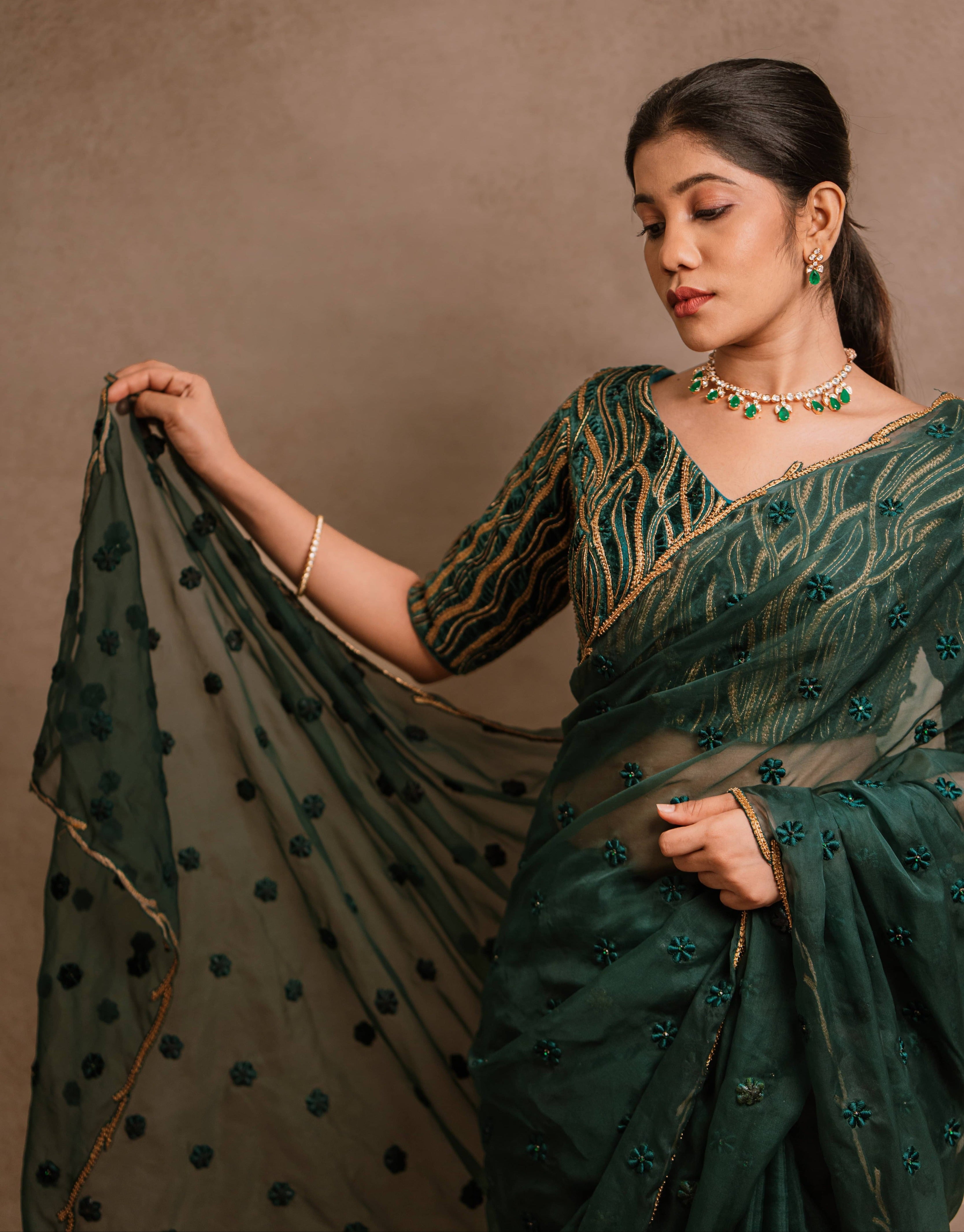 Jaina Parmar, known for recreating looks of actress Nayanthara is seen here in green organza saree set designed by Archana Karthick and is looking down showcasing the pallu
