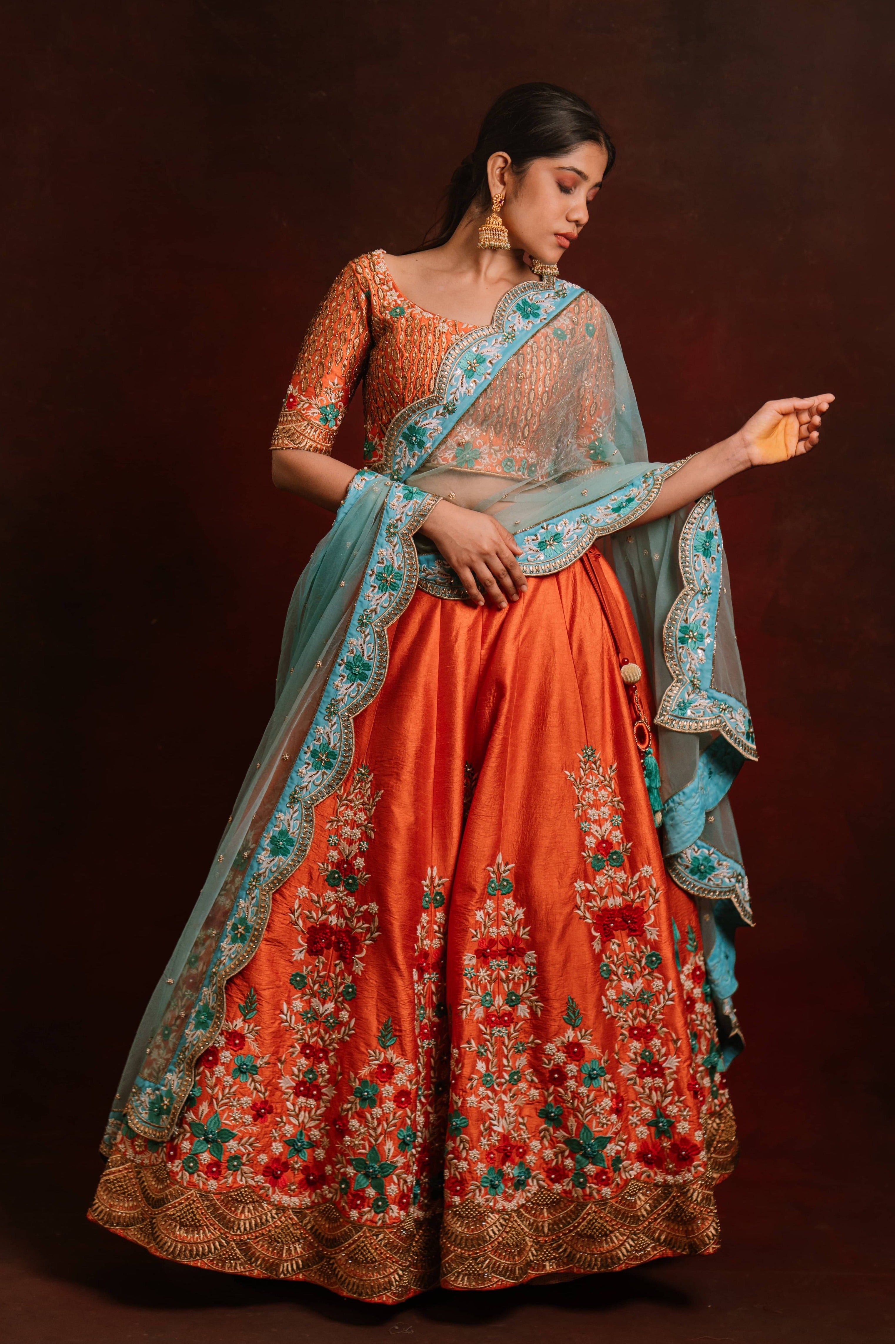 Jaina Parmar, known for recreating looks of actress Nayanthara is seen here posing in a raw silk burnt orange lehenga with blue net dupatta.