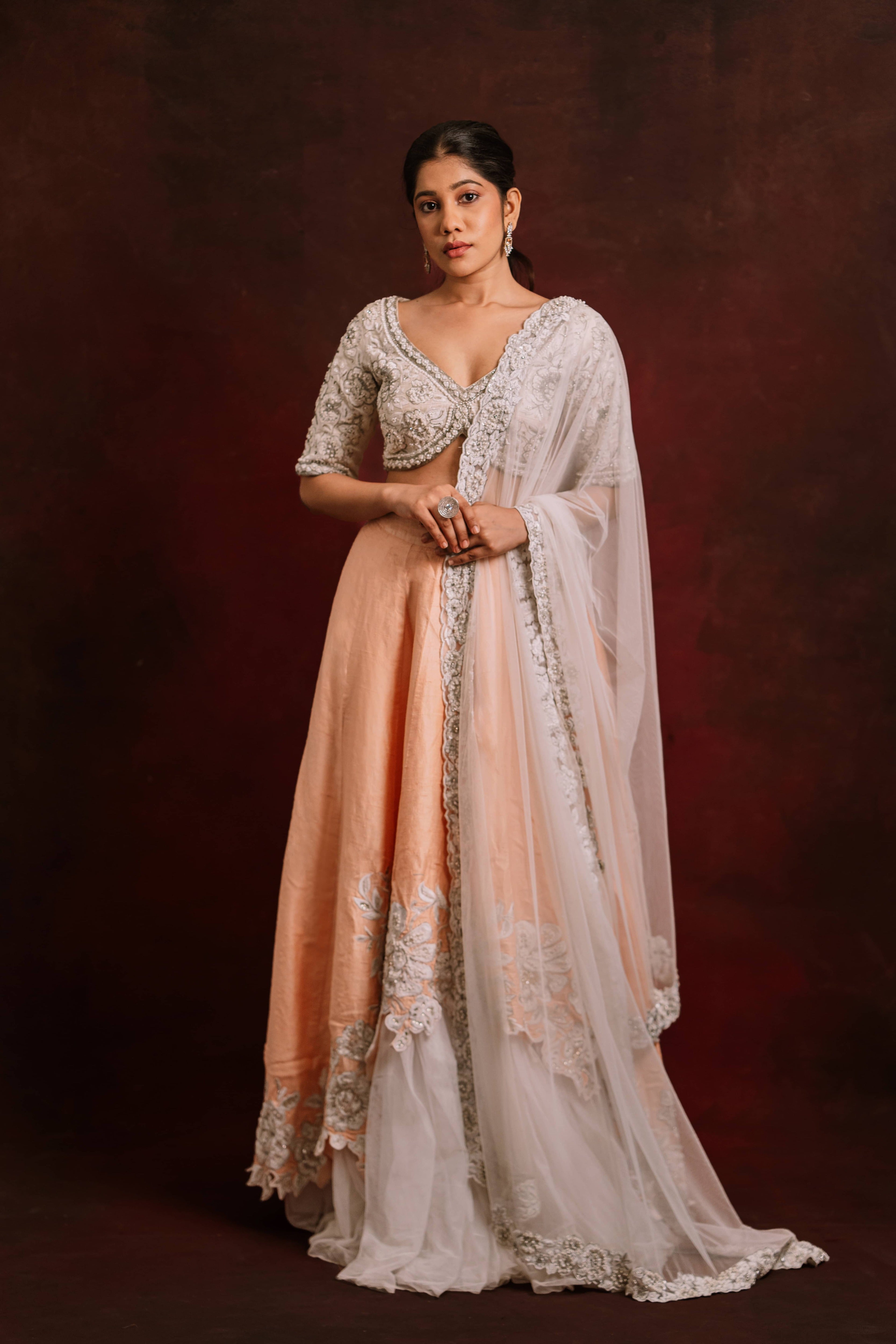 Jaina Parmar, known for recreating looks of actress Nayanthara is seen here posing in an ivory and peach raw silk lehenga with net dupatta.