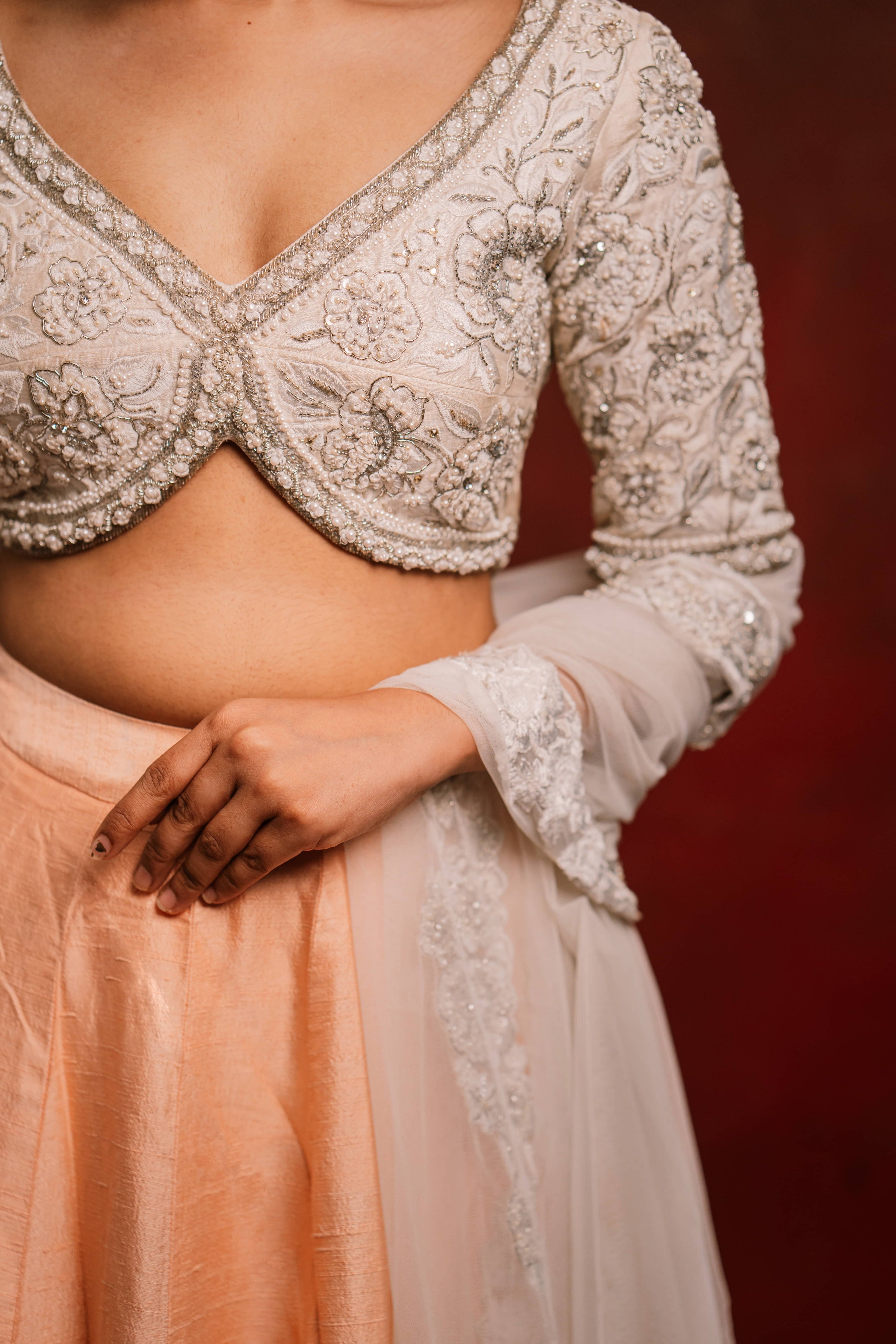Jaina Parmar, known for recreating looks of actress Nayanthara is seen here posing in an ivory and peach raw silk lehenga with net dupatta. blouse front design captured