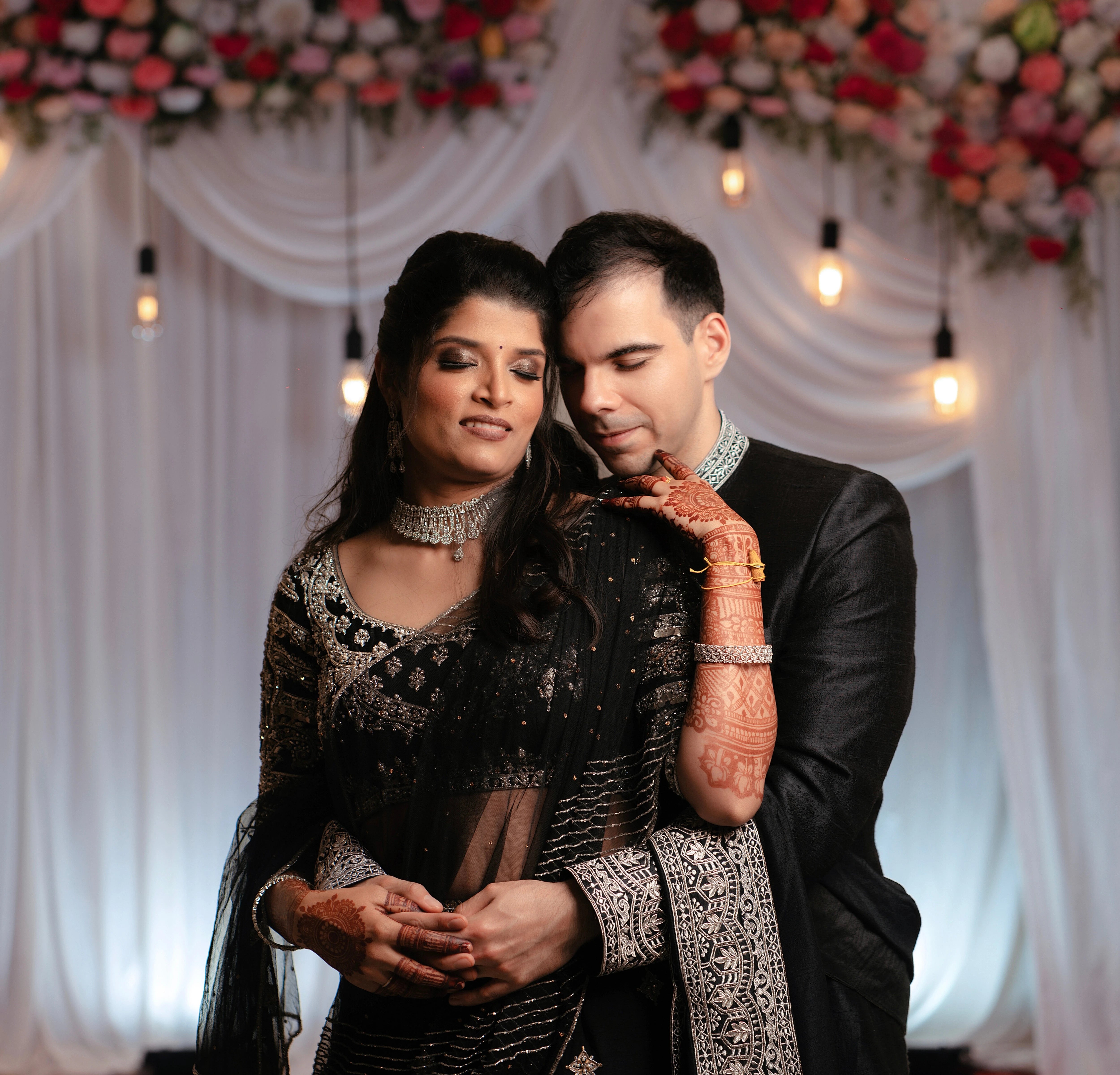 Kamakshi & Alex from Yokosuka, Japan, posing in a black raw silk lehenga and sherwani handcrafted by team Archana Karthick.