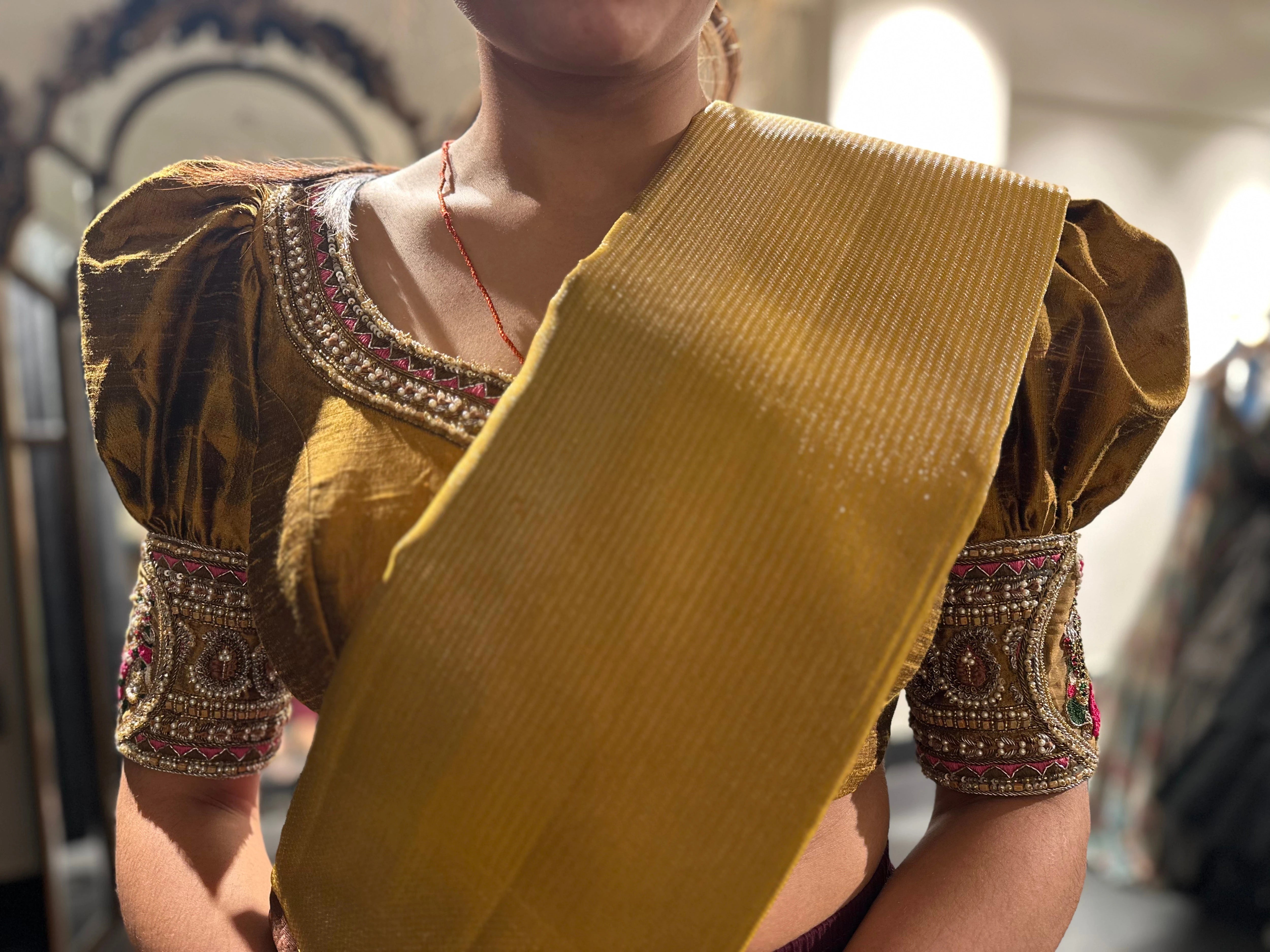 Kamakshi from Yokosuka, Japan, during fittings in a mustard silk blouse handcrafted by team Archana Karthick.