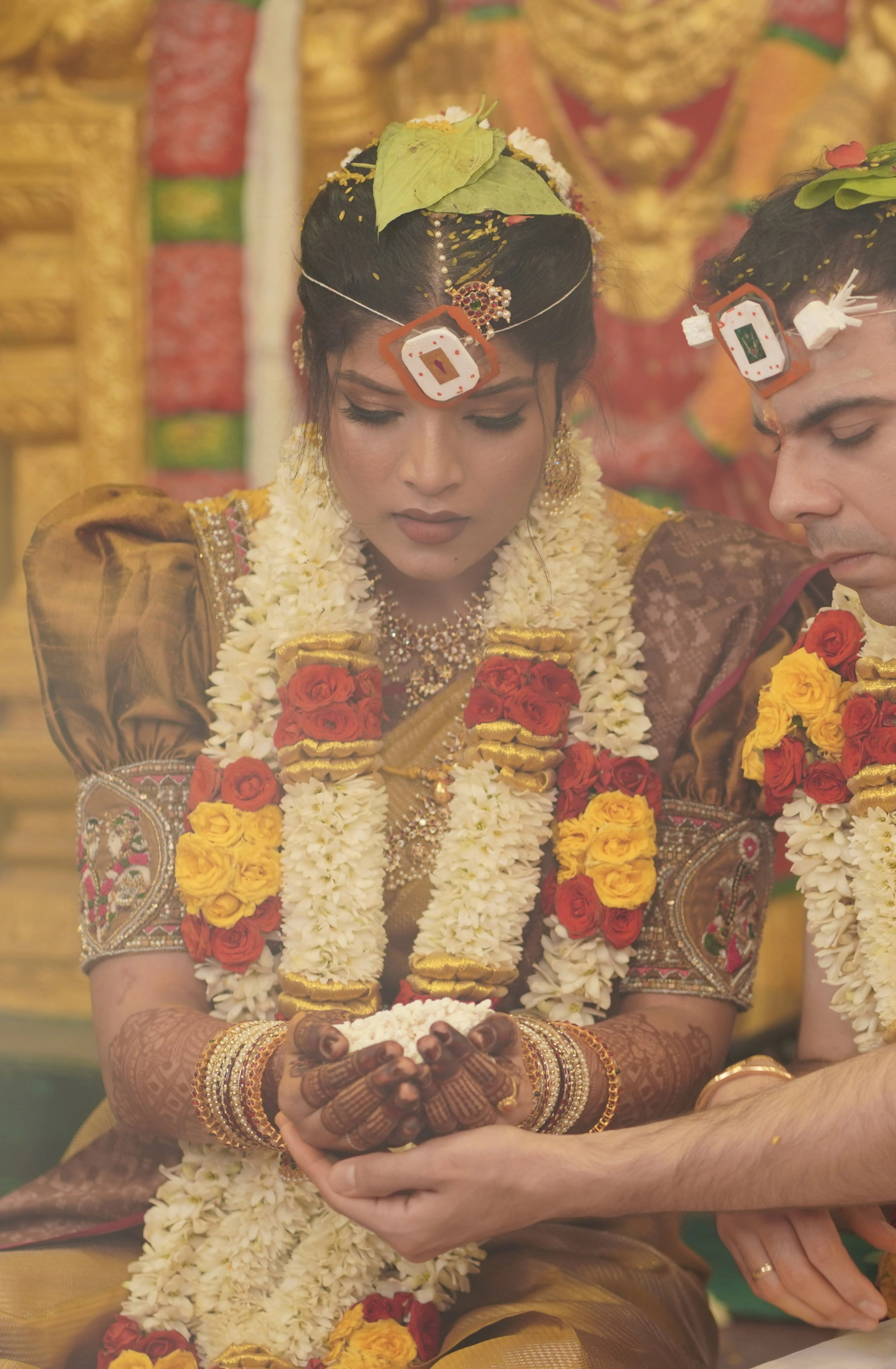 Kamakshi from Yokosuka, Japan, during rituals in a mustard silk blouse handcrafted by team Archana Karthick.