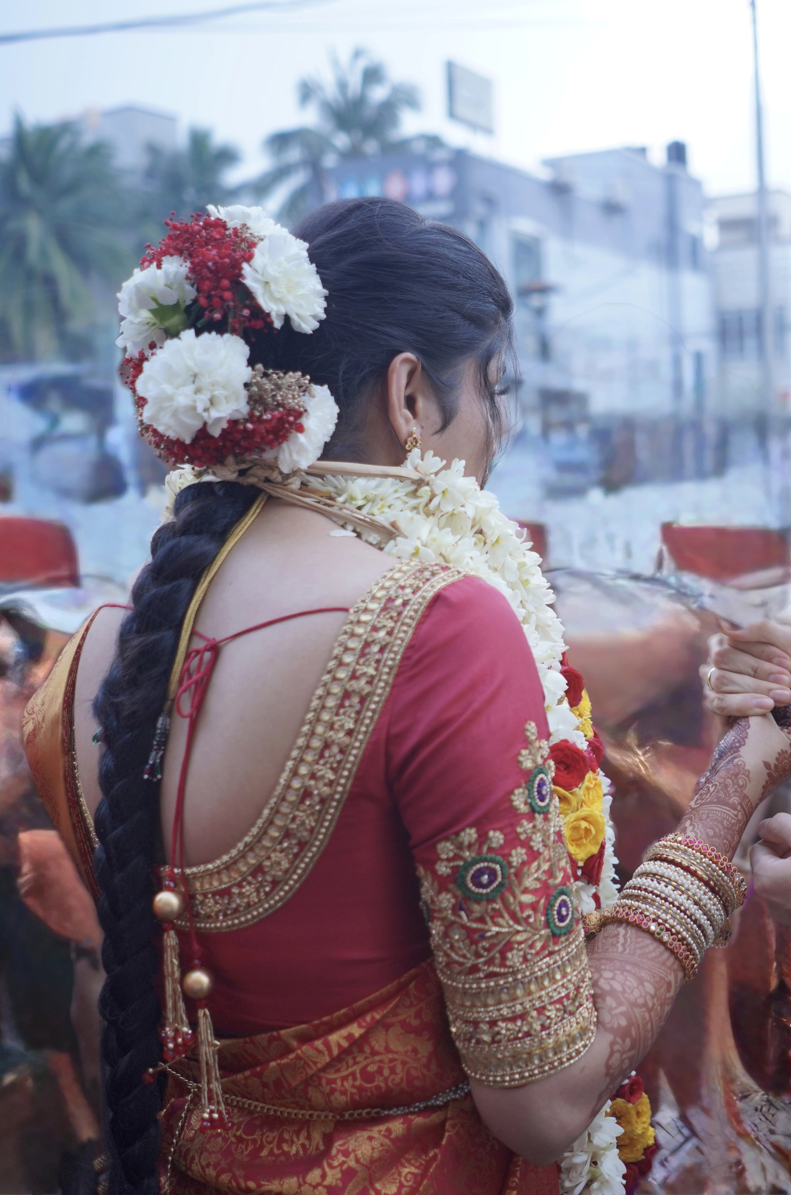 Kamakshi from Yokosuka, Japan, posing in a red silk blouse handcrafted by team Archana Karthick.