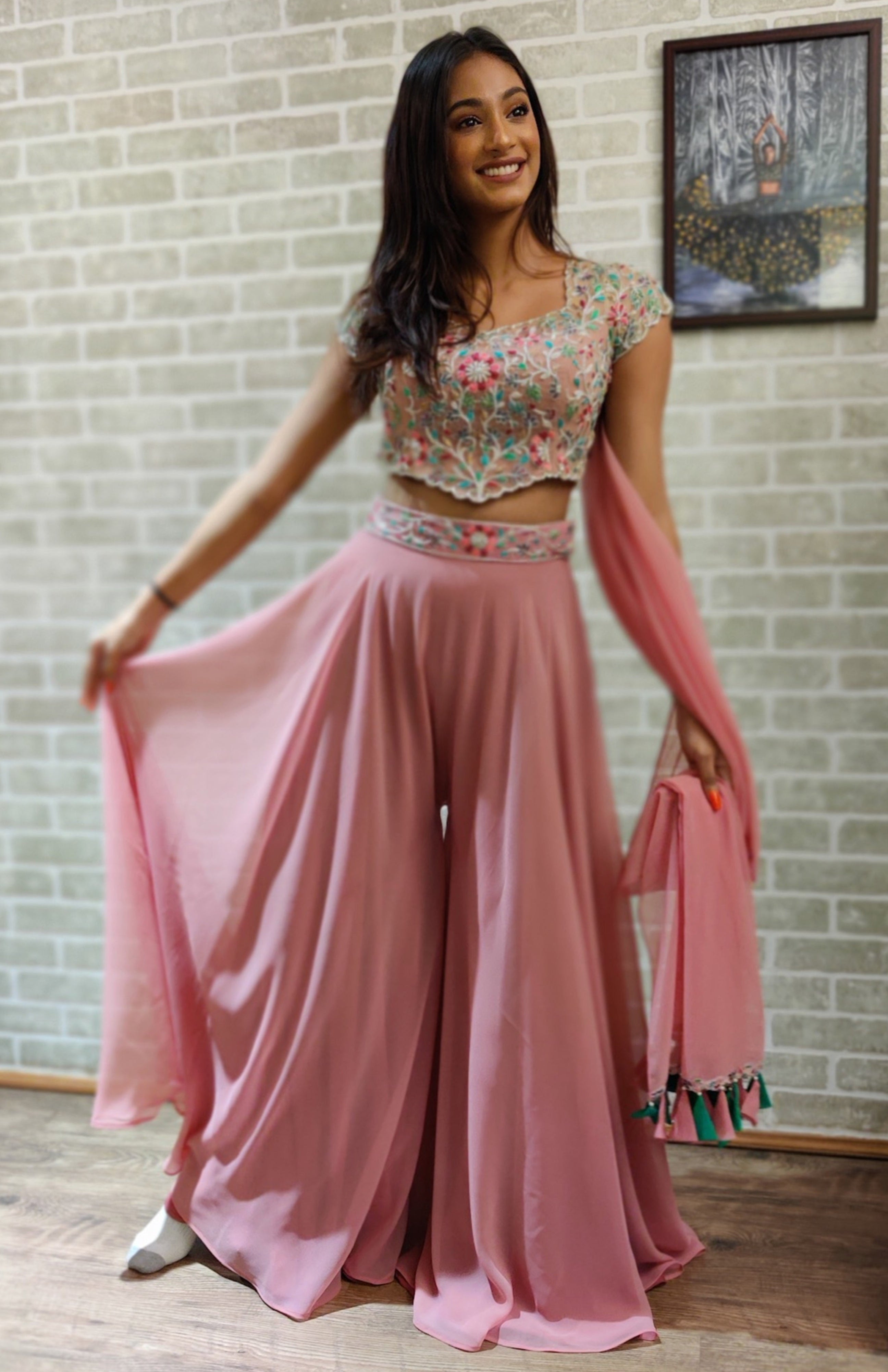 Miss India 2018 and actress Anukreethy Vas in a powder pink georgette sharara with palazzo pants. Looking away from camera.