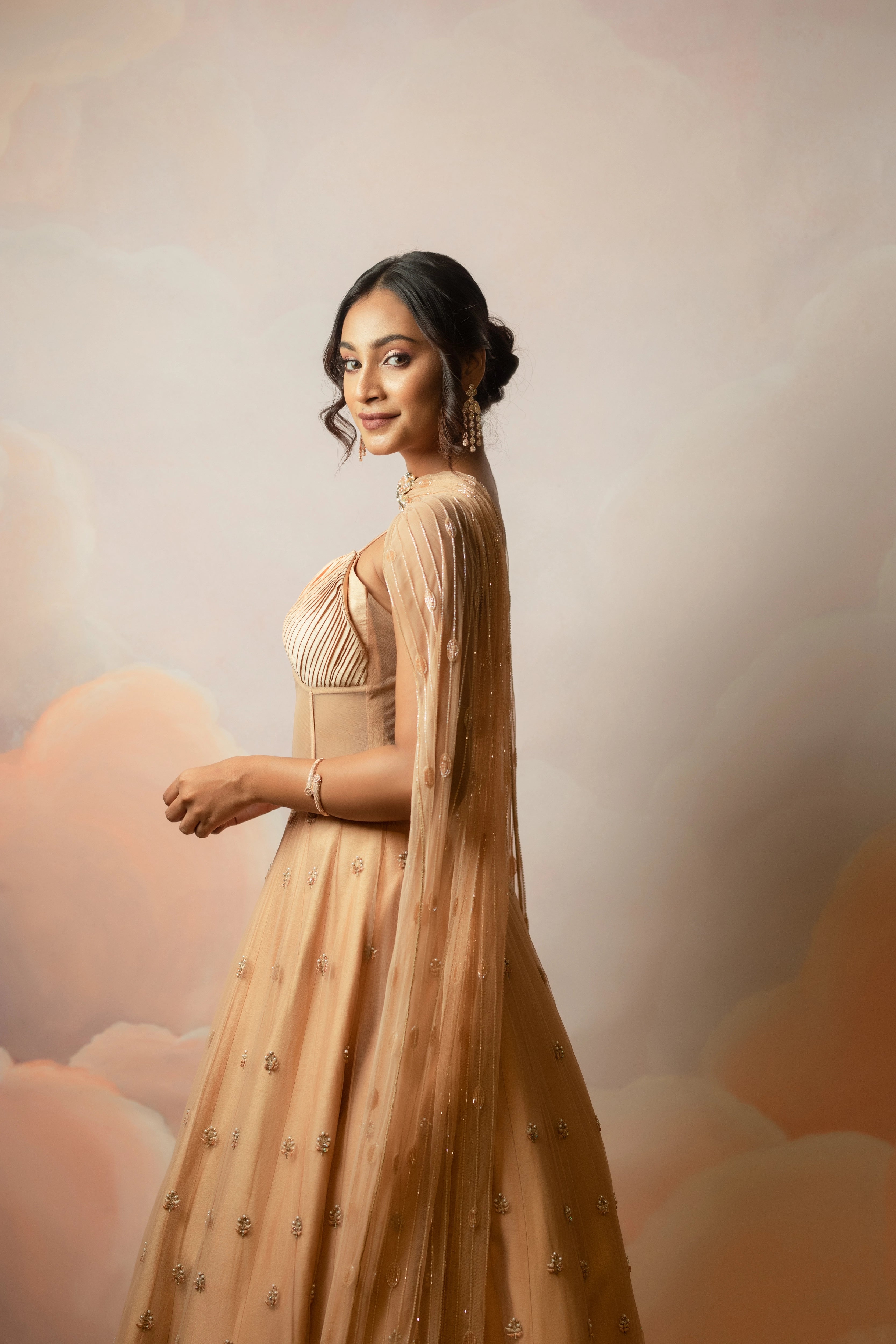 Miss India & Actress Anukreethy Vas looking right in a peach corset gown with draped dupatta, handcrafted with sequin, resham, cutdana, beads and stones by Archana Karthick.