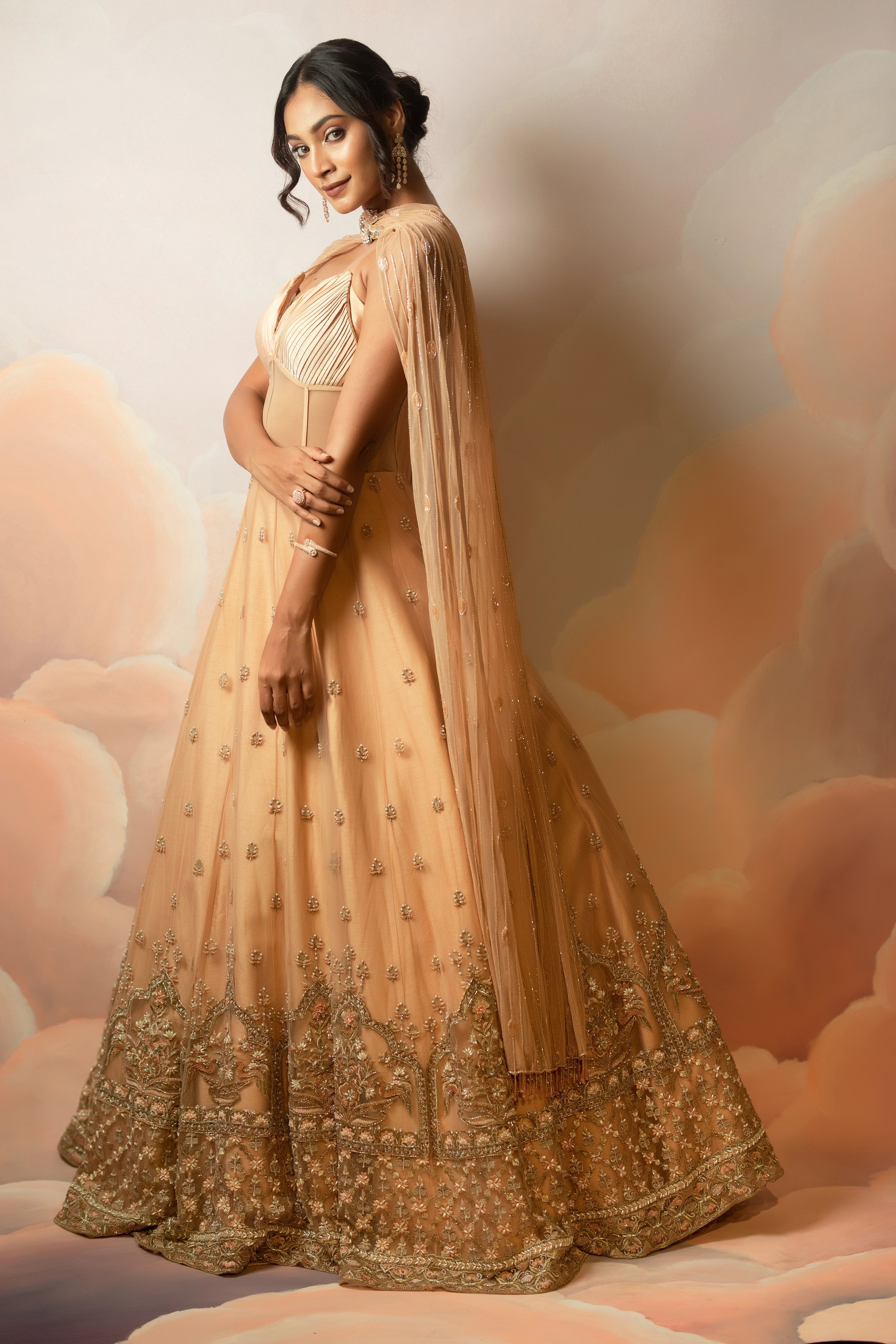 Miss India & Actress Anukreethy Vas showcasing side profile in a peach corset gown with draped dupatta, handcrafted with sequin, resham, cutdana, beads and stones by Archana Karthick.