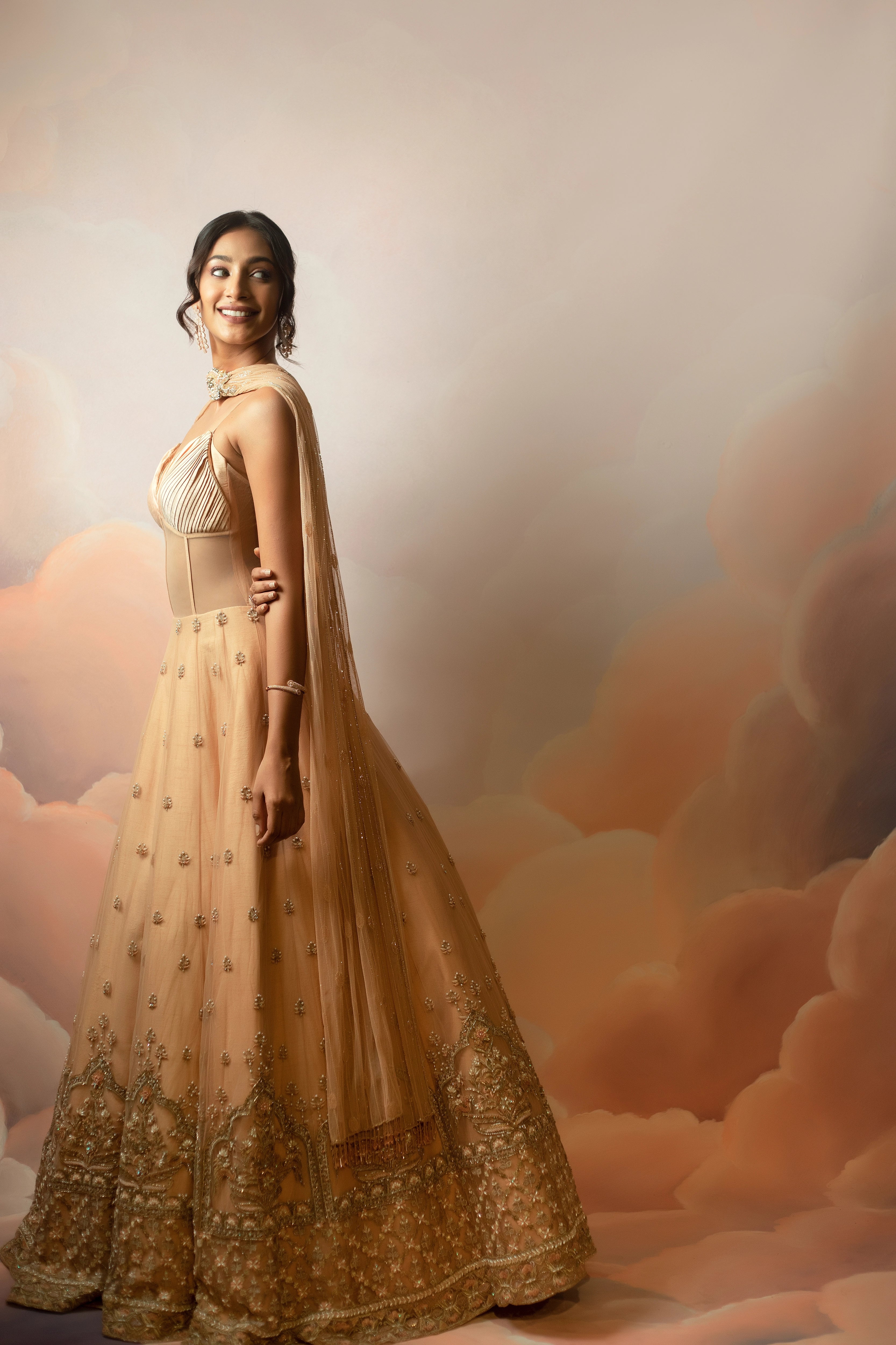 Miss India & Actress Anukreethy Vas smiling in a peach corset gown with draped dupatta, handcrafted with sequin, resham, cutdana, beads and stones by Archana Karthick.
